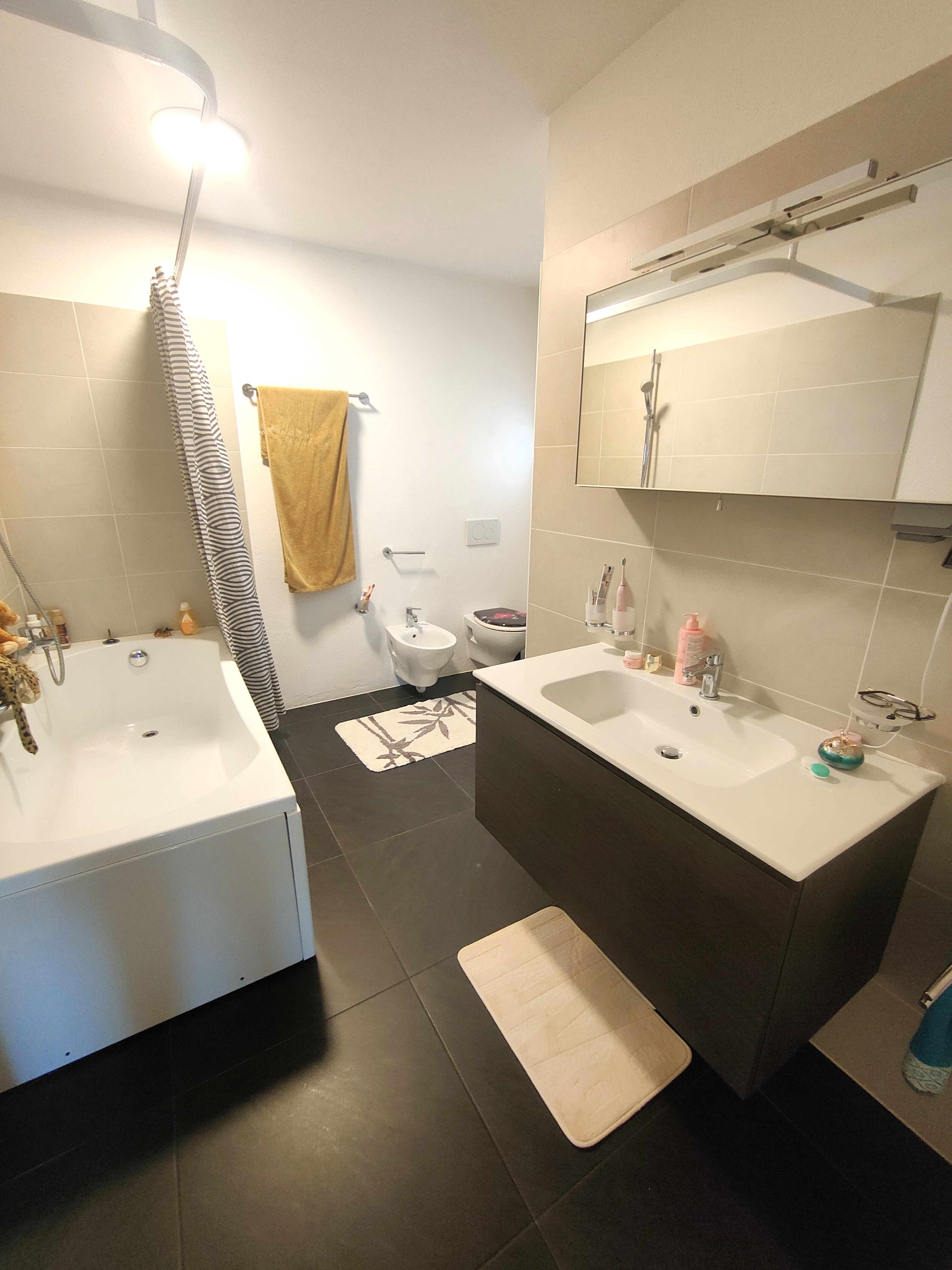 Modernes Badezimmer mit Badewanne, Doppelwaschtisch und Wand-WC