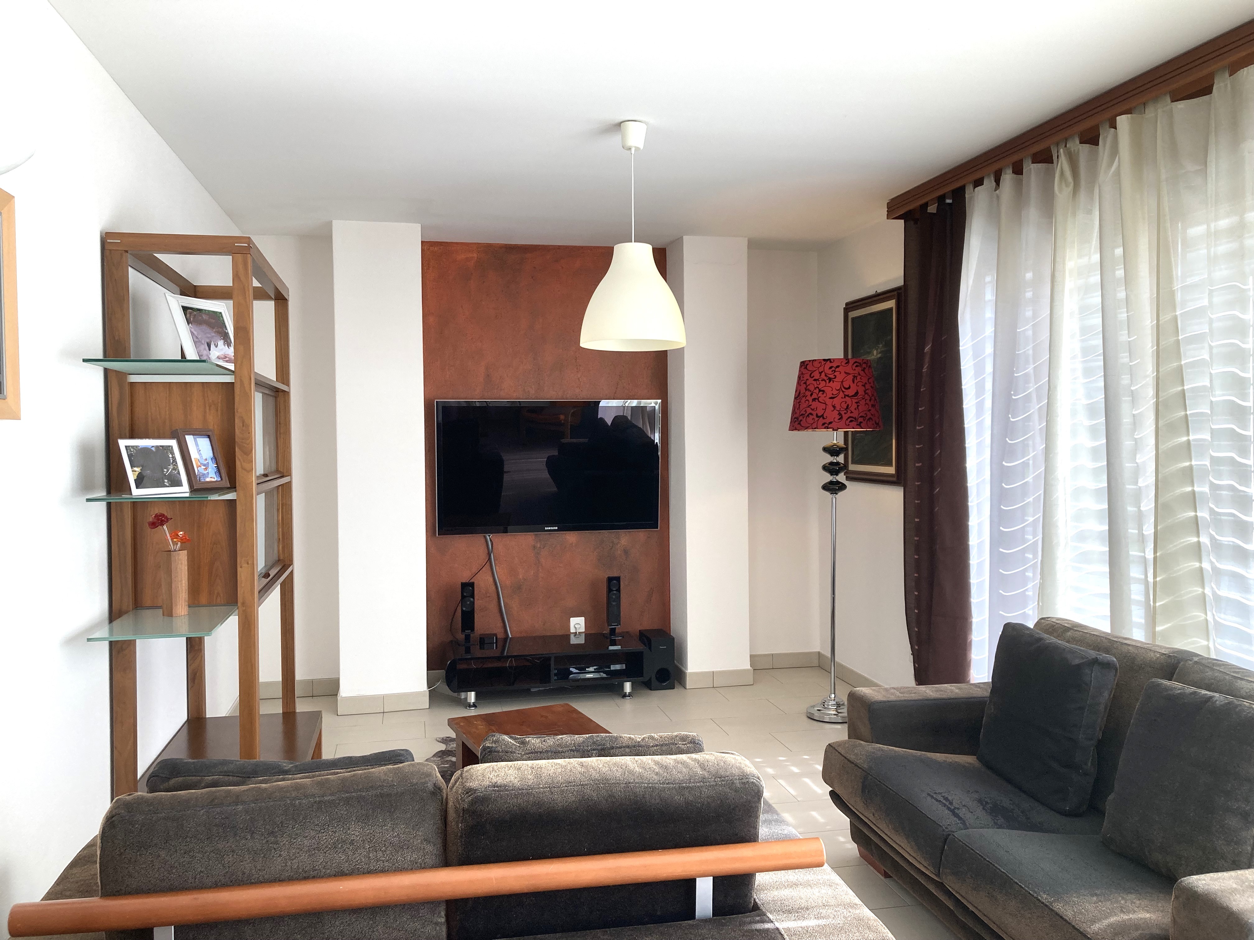 Wohnzimmer mit TV-Wand und Sofalandschaft