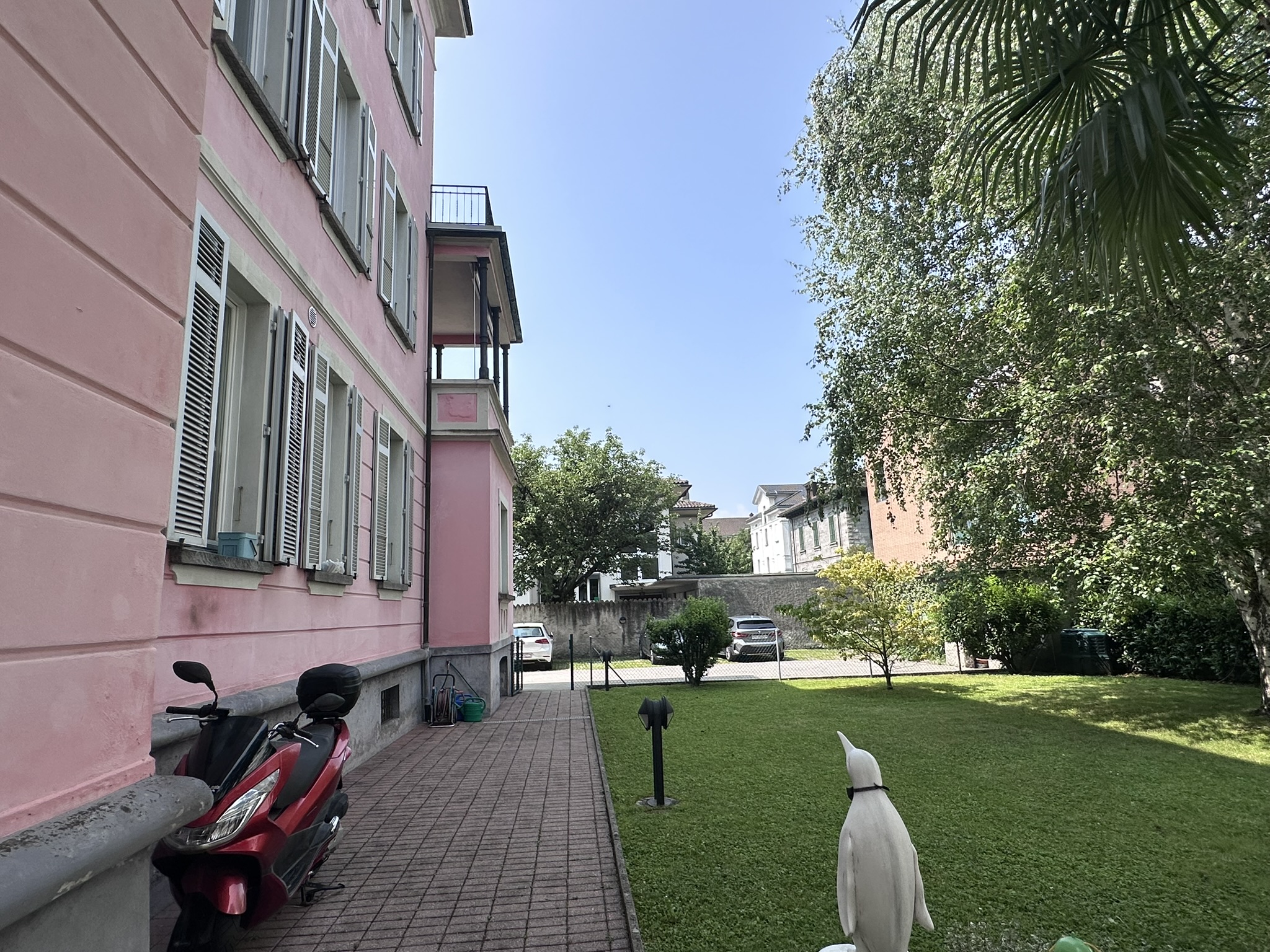 Rosafarbene Altbaufassade mit Garten