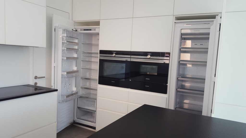 Moderne weiße Küche mit schwarzen Arbeitsflächen