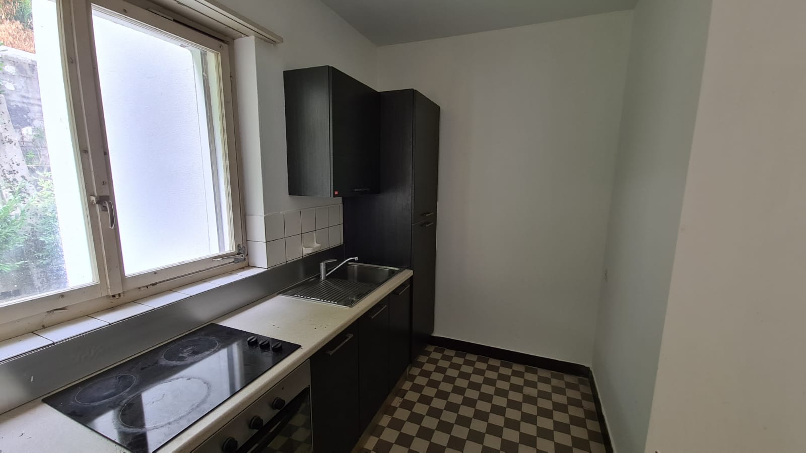 Kleine Küche mit Fenster und dunklen Fronten