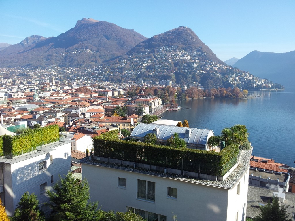 Panoramablick auf Stadt, See und Berge