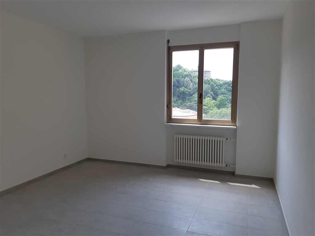 Leerer heller Raum mit Fenster und Heizkörper