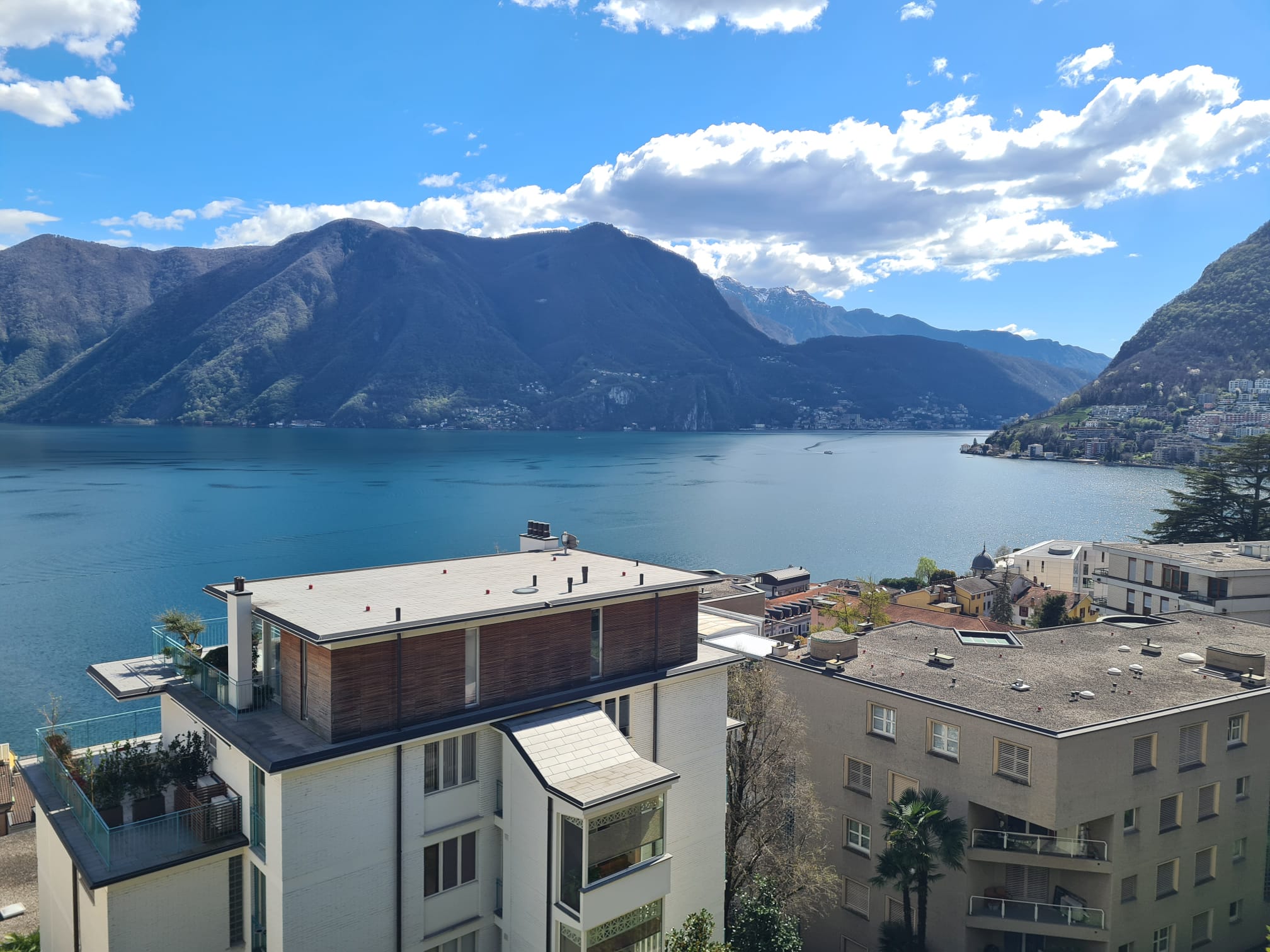 Seeblick mit Bergen und Wohngebäuden