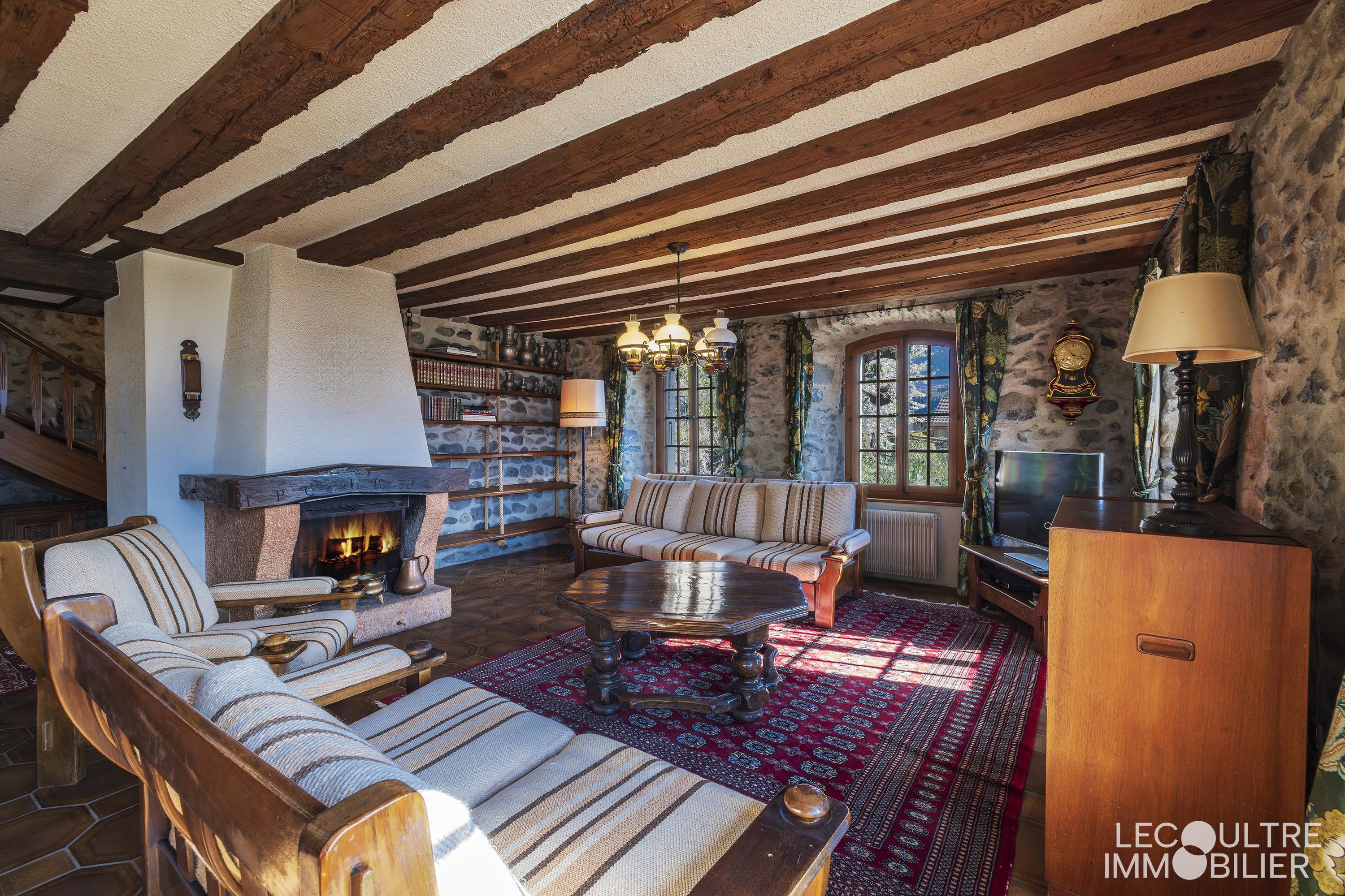 Rustikales Wohnzimmer mit Kamin und Holzdeckenbalken