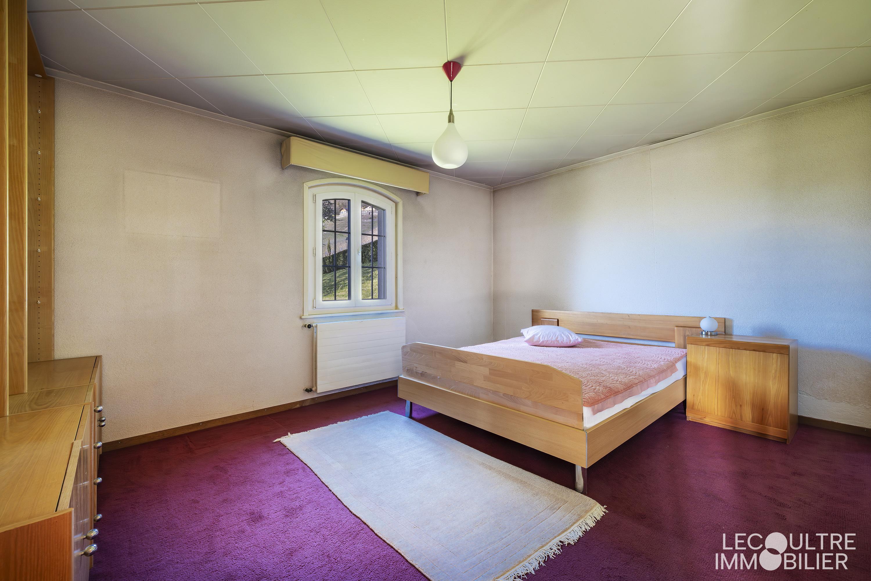 Schlichtes Schlafzimmer mit Bett und Fenster