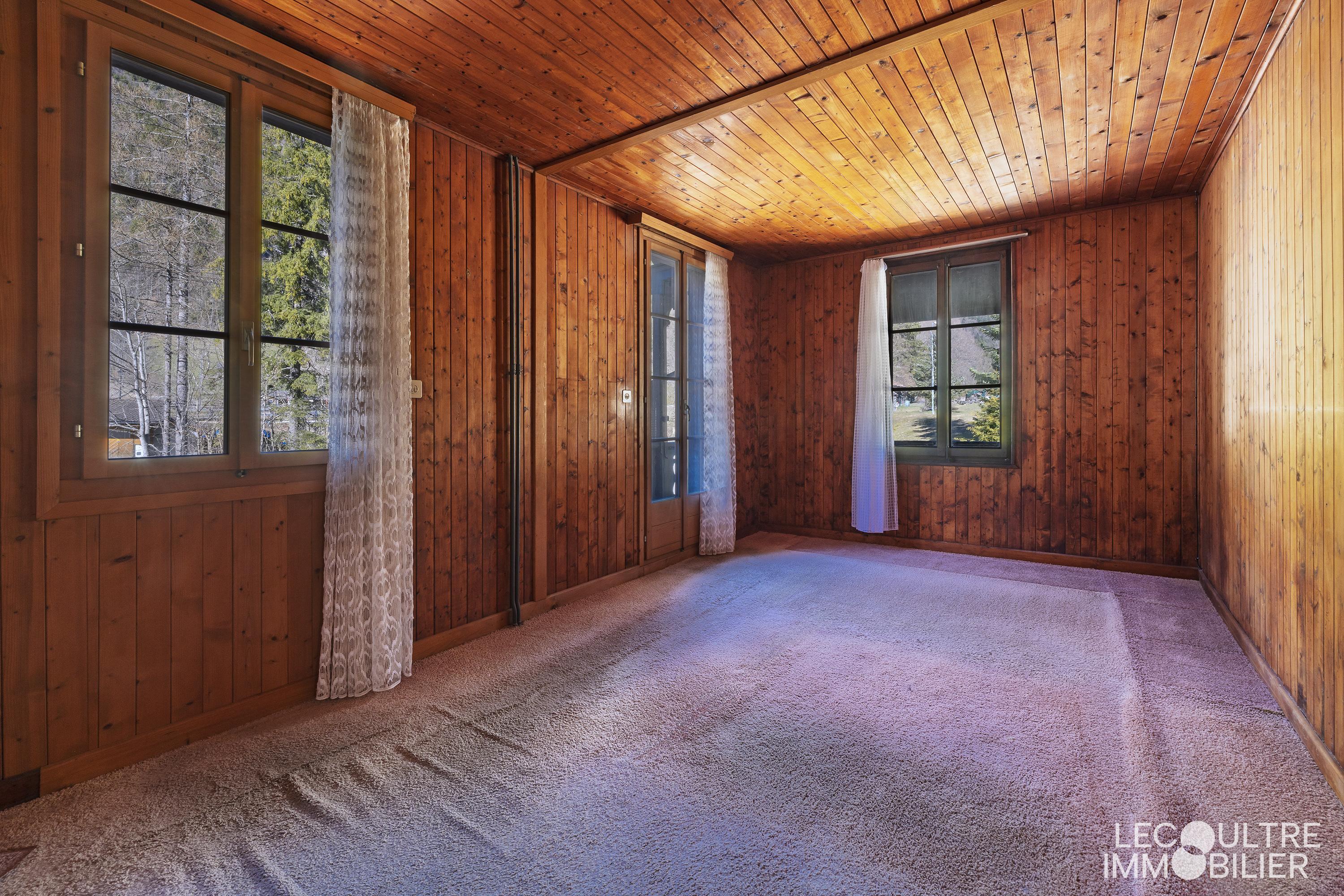 Leeres, holzvertäfeltes Zimmer mit Teppichboden