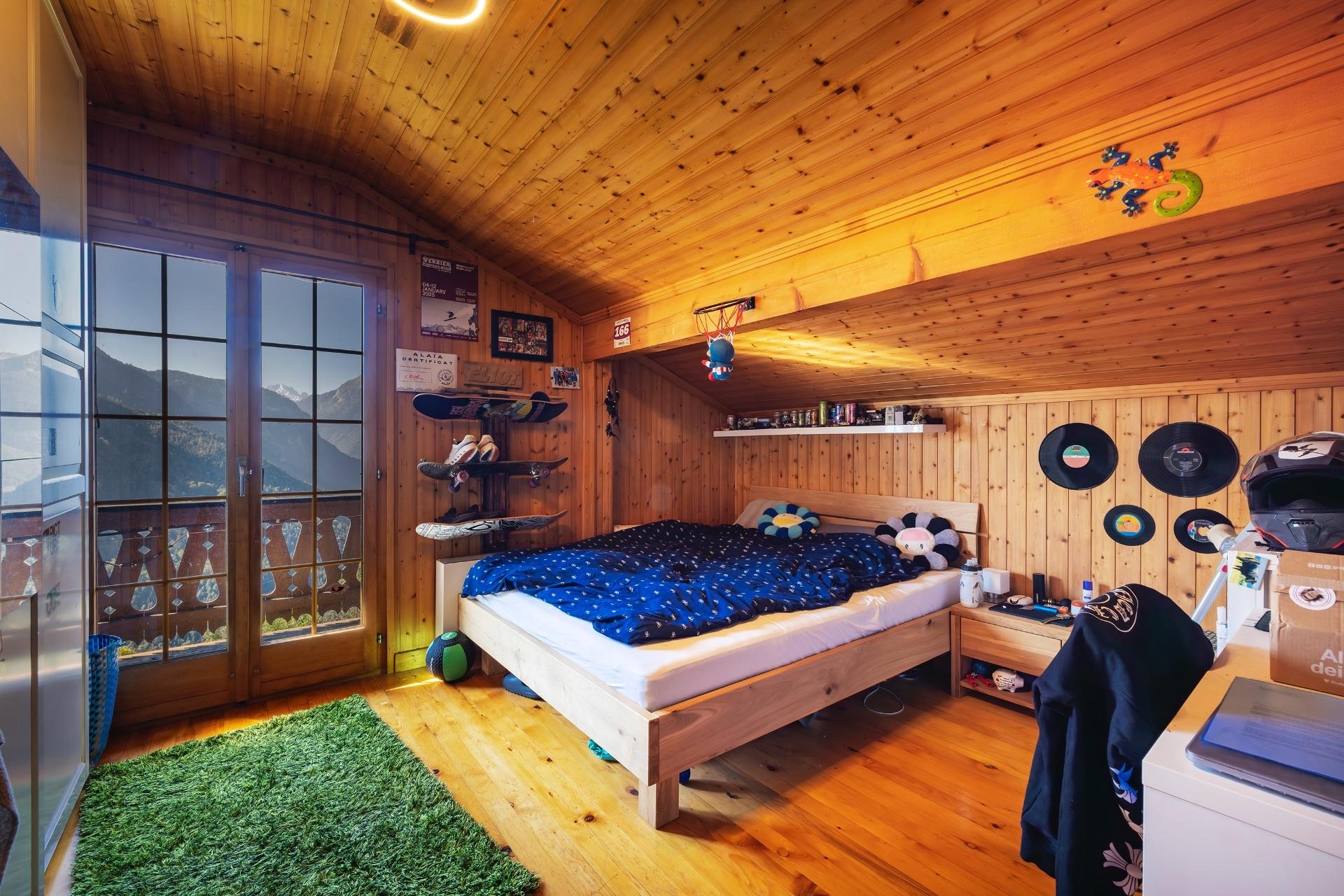 Holzverkleidetes Schlafzimmer mit Bergblick
