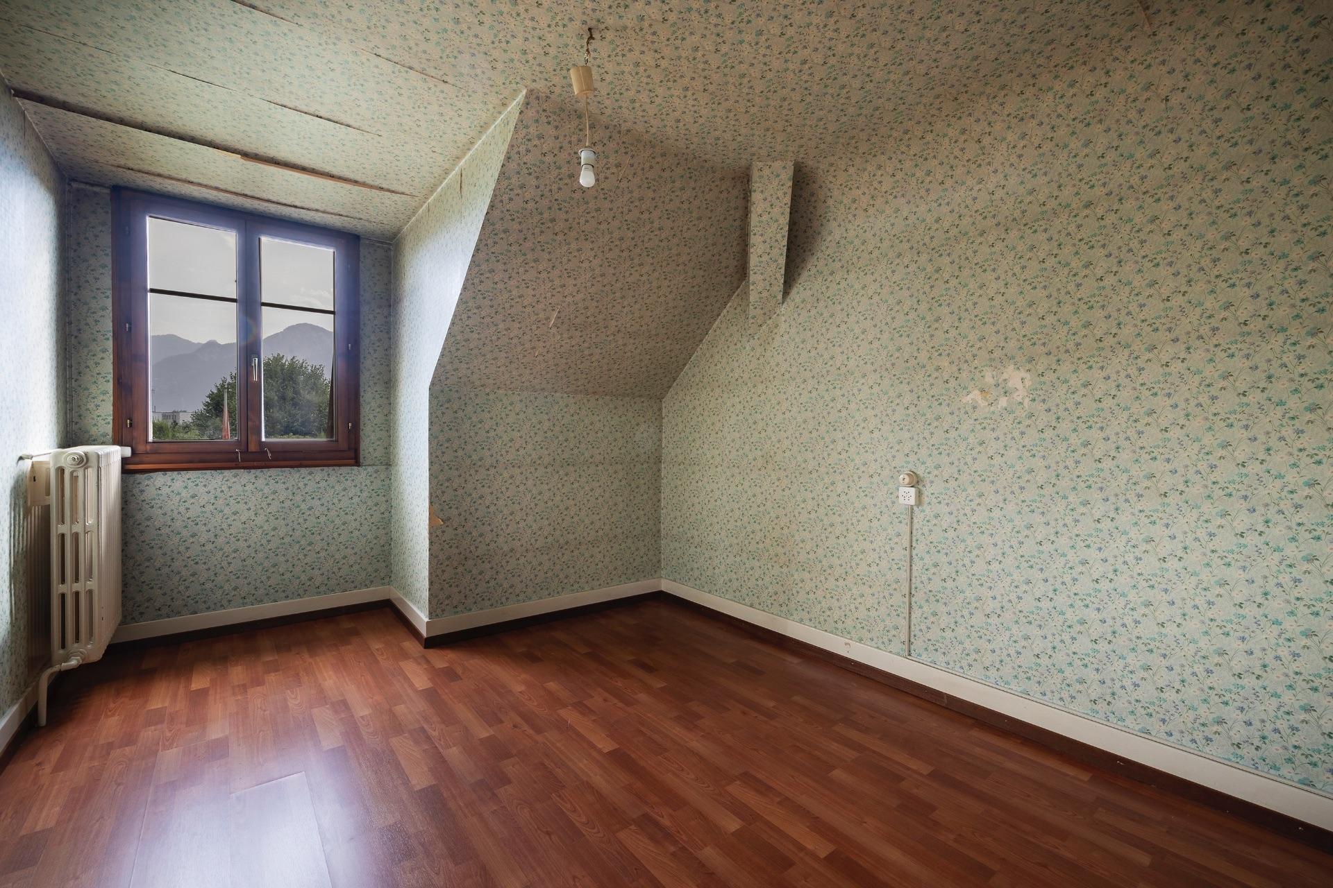 Dachgeschosszimmer mit Blumenmuster und Blick ins Grüne