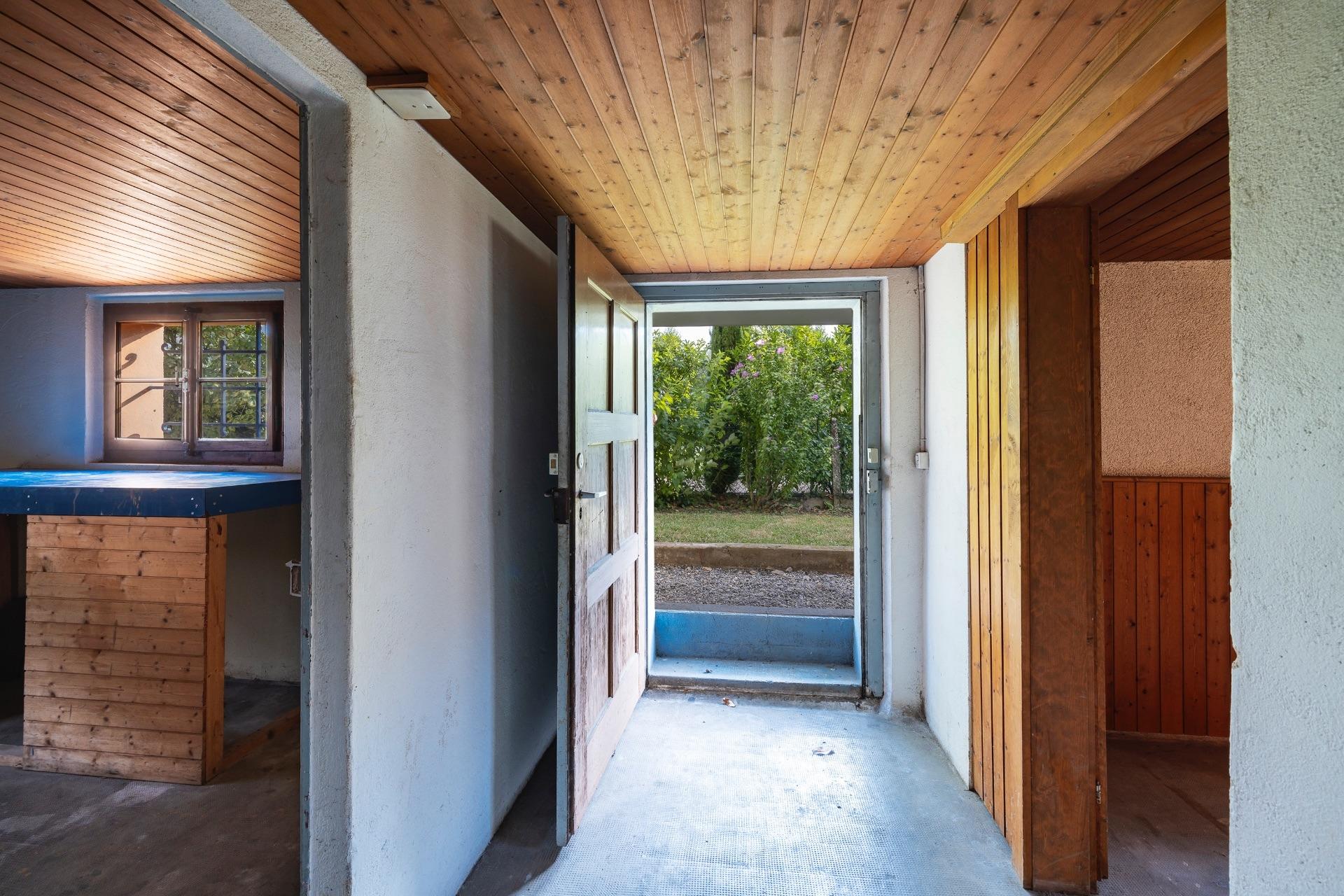 Eingangsbereich mit Holzdecke und Gartenblick