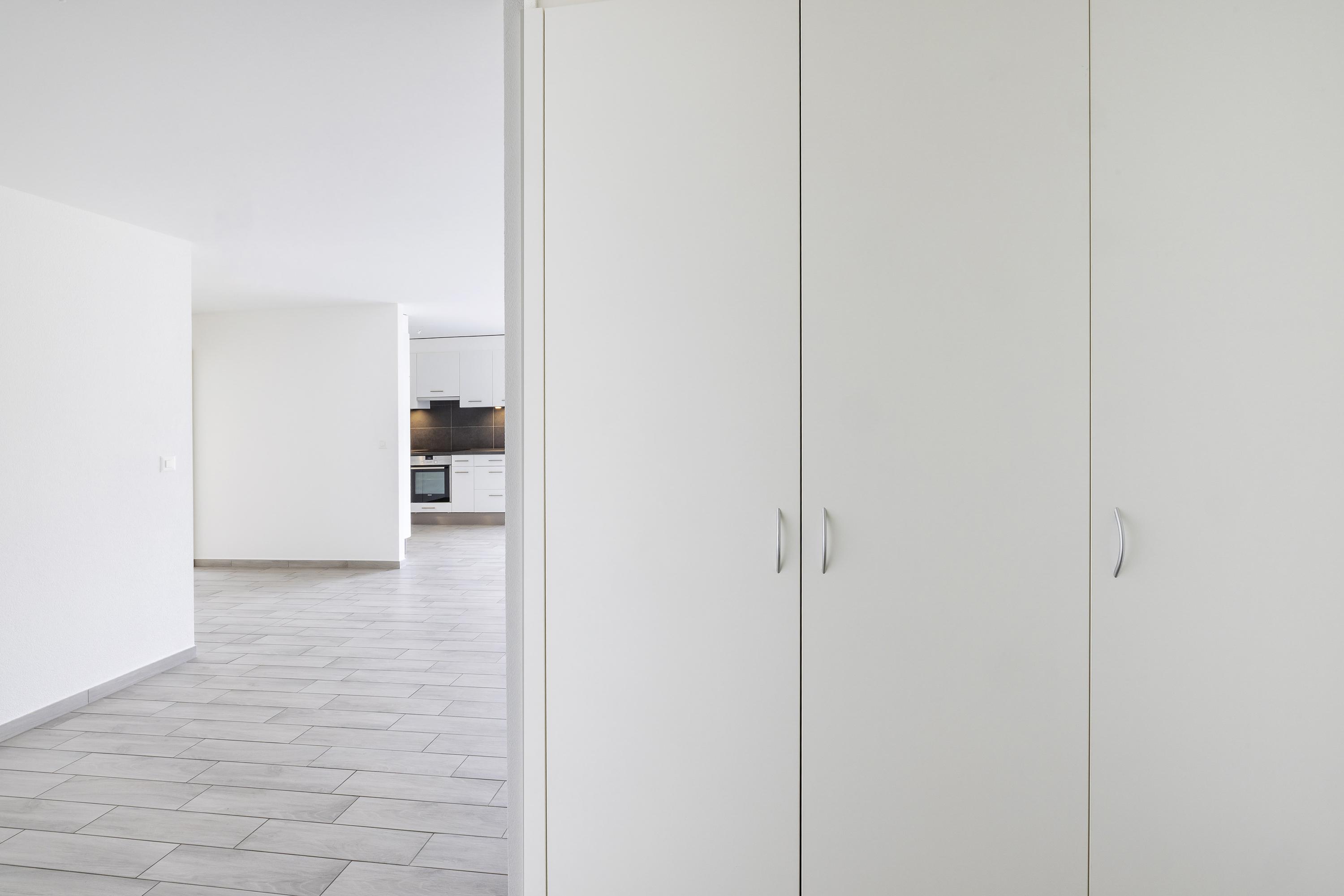 Heller Flur mit Einbauschrank und Blick zur Küche