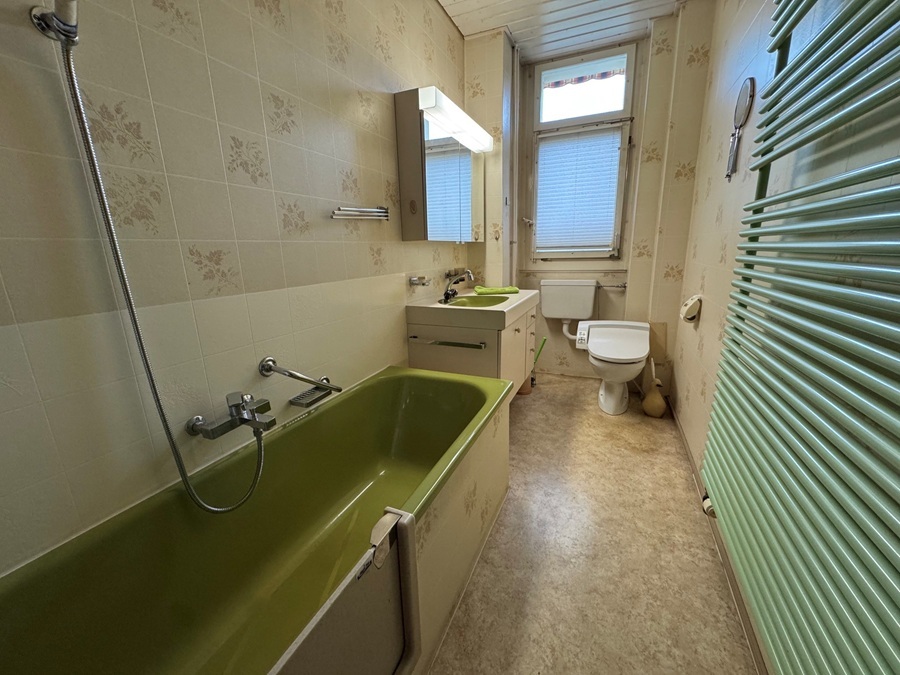 Langes Badezimmer mit Badewanne und WC