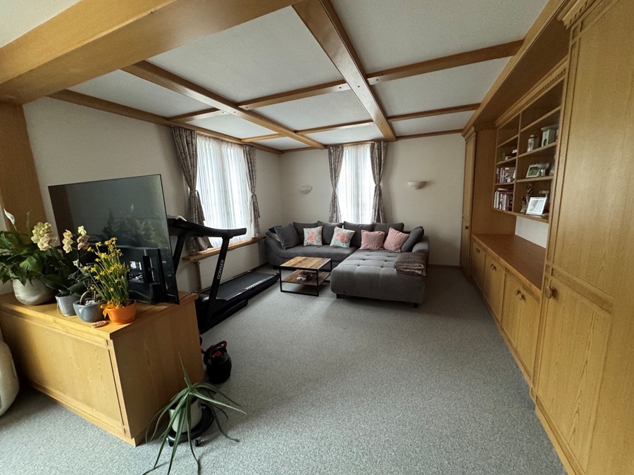 Wohnzimmer mit Holzvertäfelung und Teppichboden