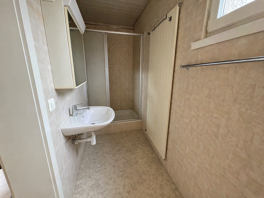 Schmales Badezimmer mit Dusche und Waschbecken