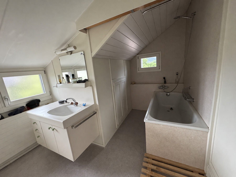 Kleines Dachgeschossbad mit Badewanne und Waschtisch
