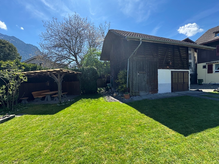 Garten mit Holzgebäude und überdachtem Sitzplatz