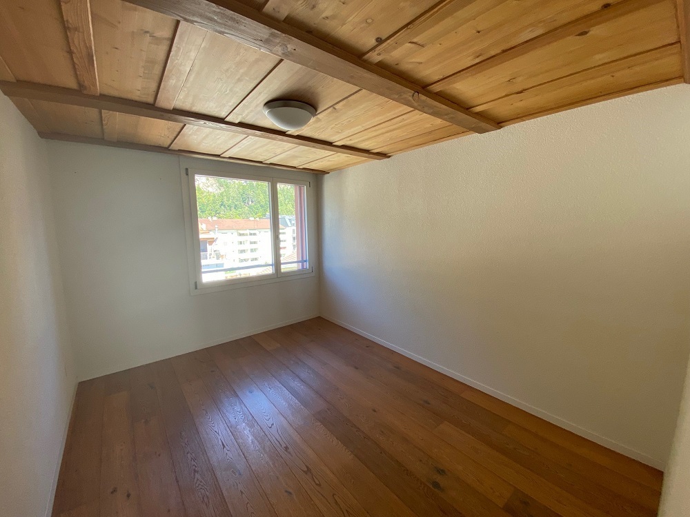 Leerer Dachraum mit Holzdecke und Parkettboden