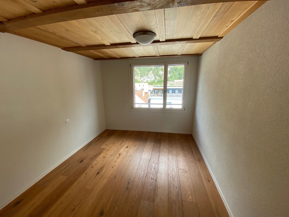 Kleines Zimmer mit Holzdecke und Parkettboden