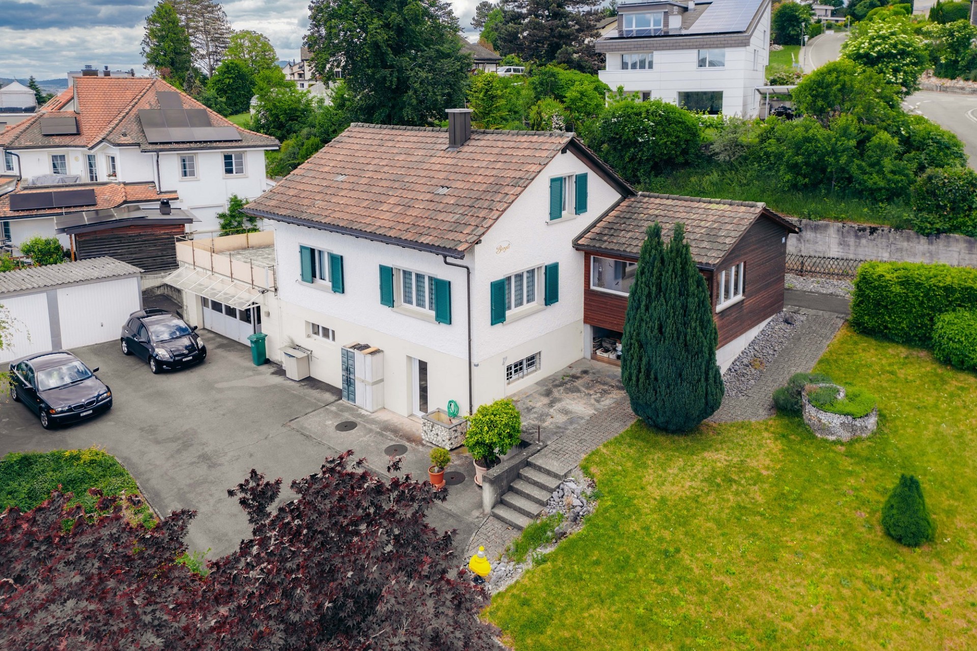Luftaufnahme eines Einfamilienhauses mit Garten und Zufahrt