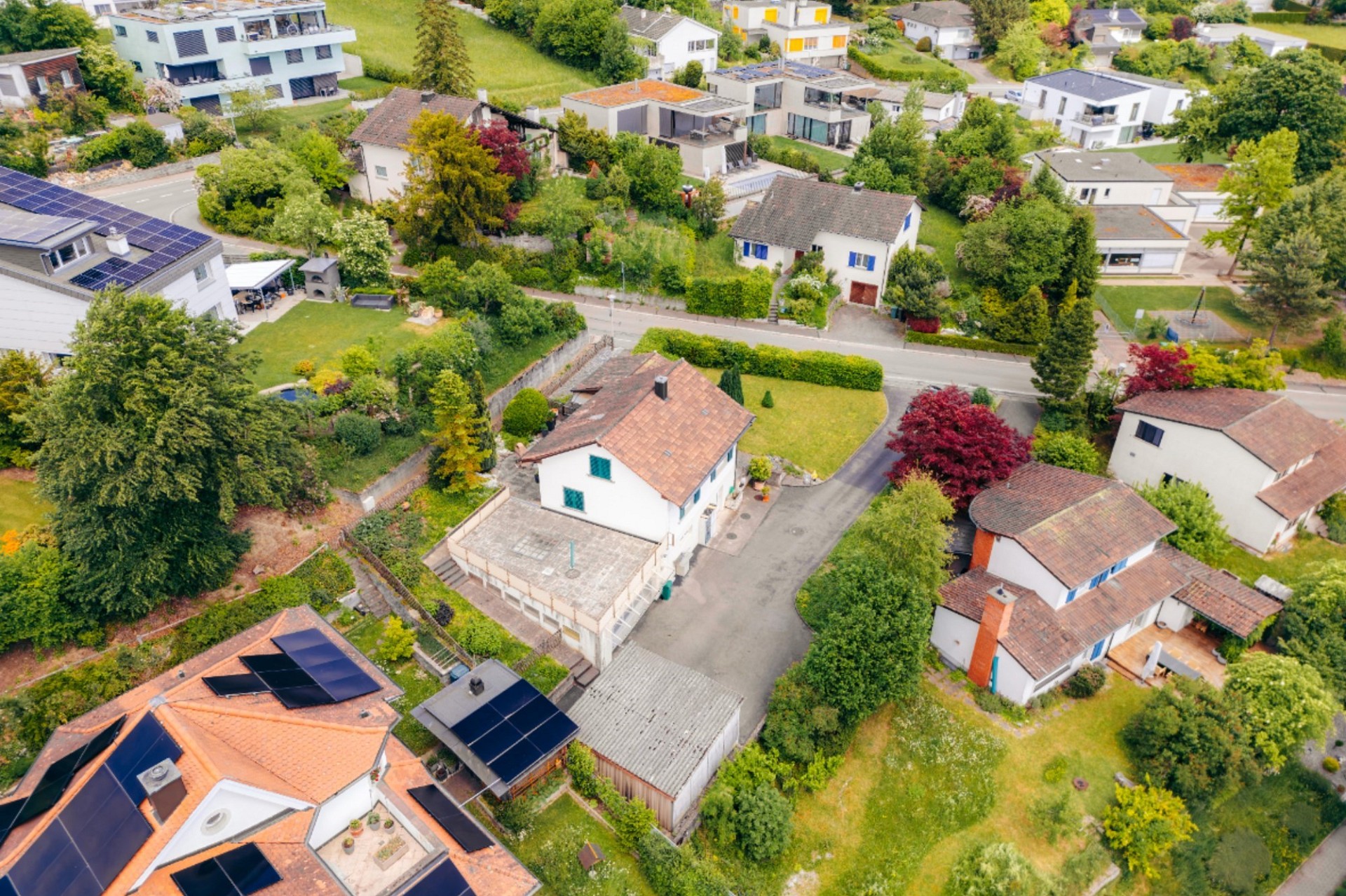 Luftaufnahme eines grünen Wohnviertels mit Häusern und Gärten