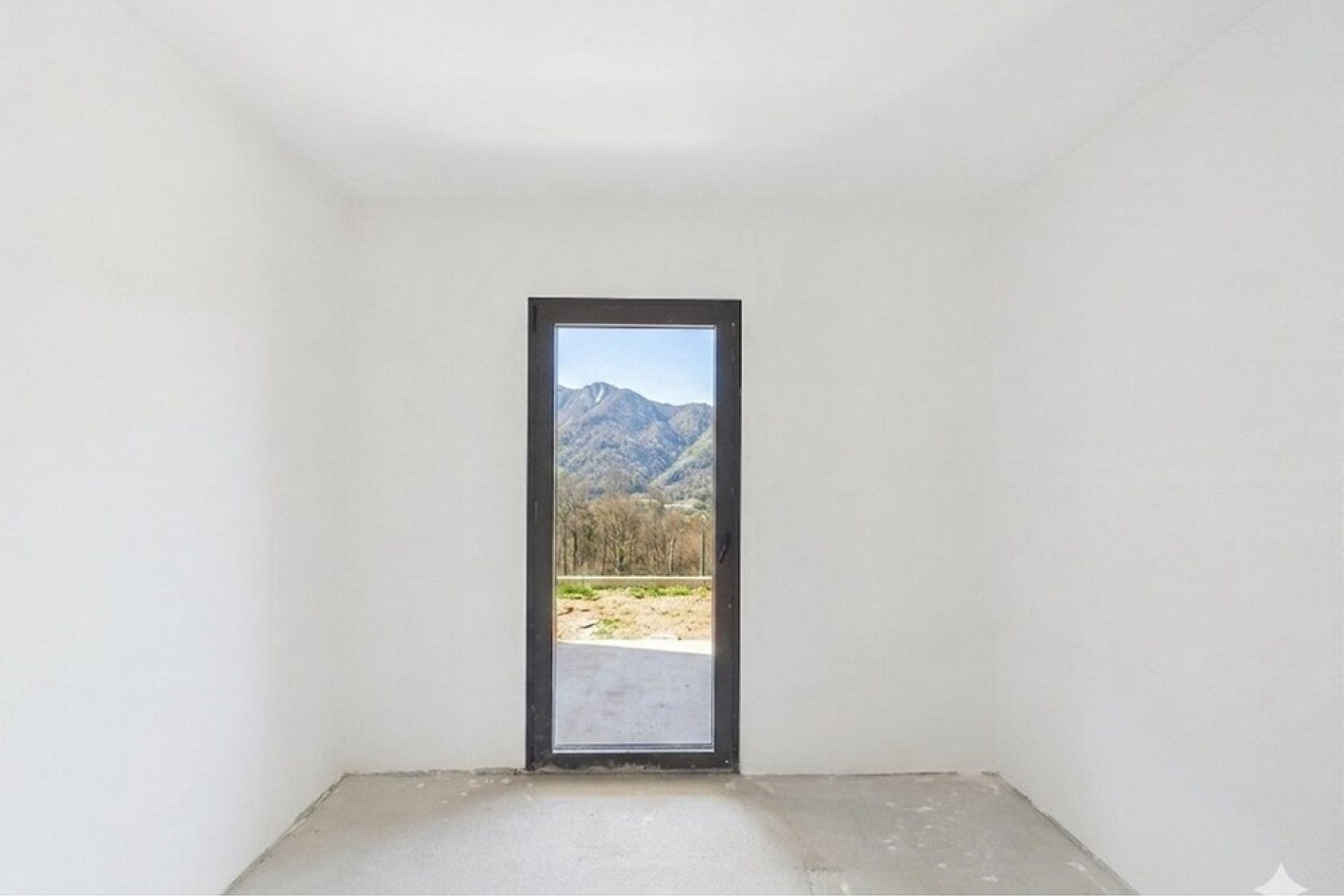 Leerer Innenraum mit schmaler Tür und Bergblick