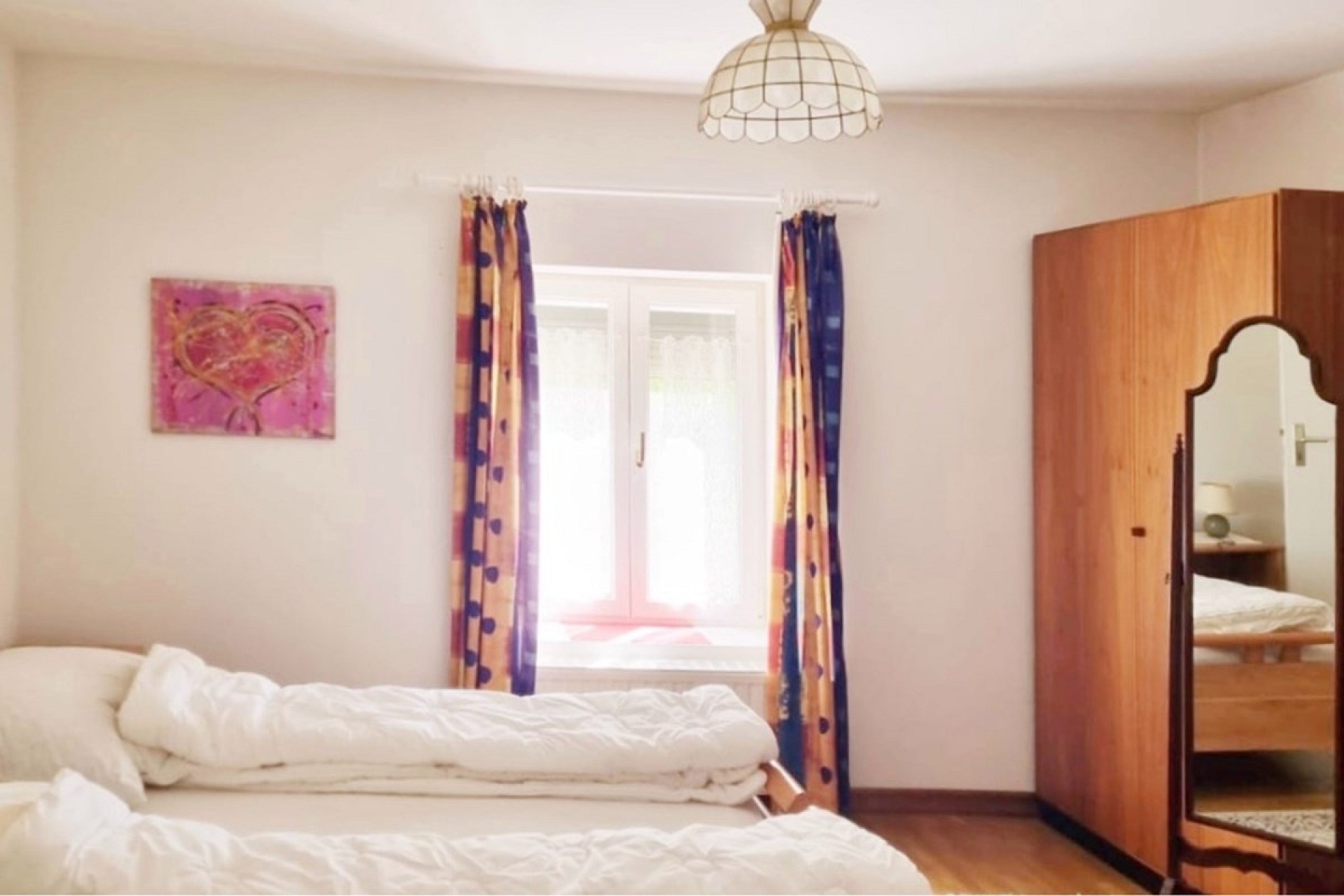 Schlichtes Schlafzimmer mit Fenster und Kleiderschrank