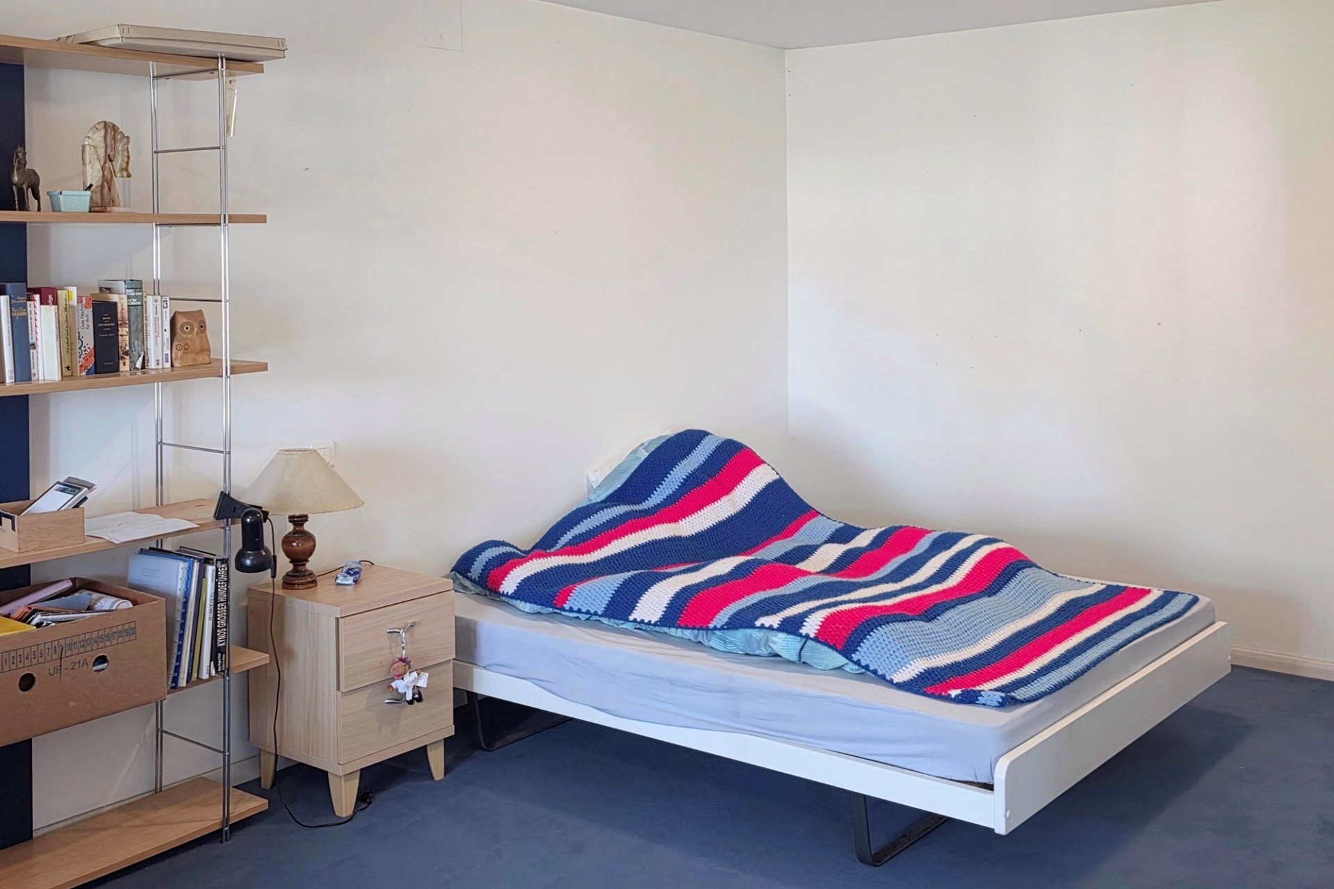 Ein kleines Schlafzimmer mit Einzelbett und Regal