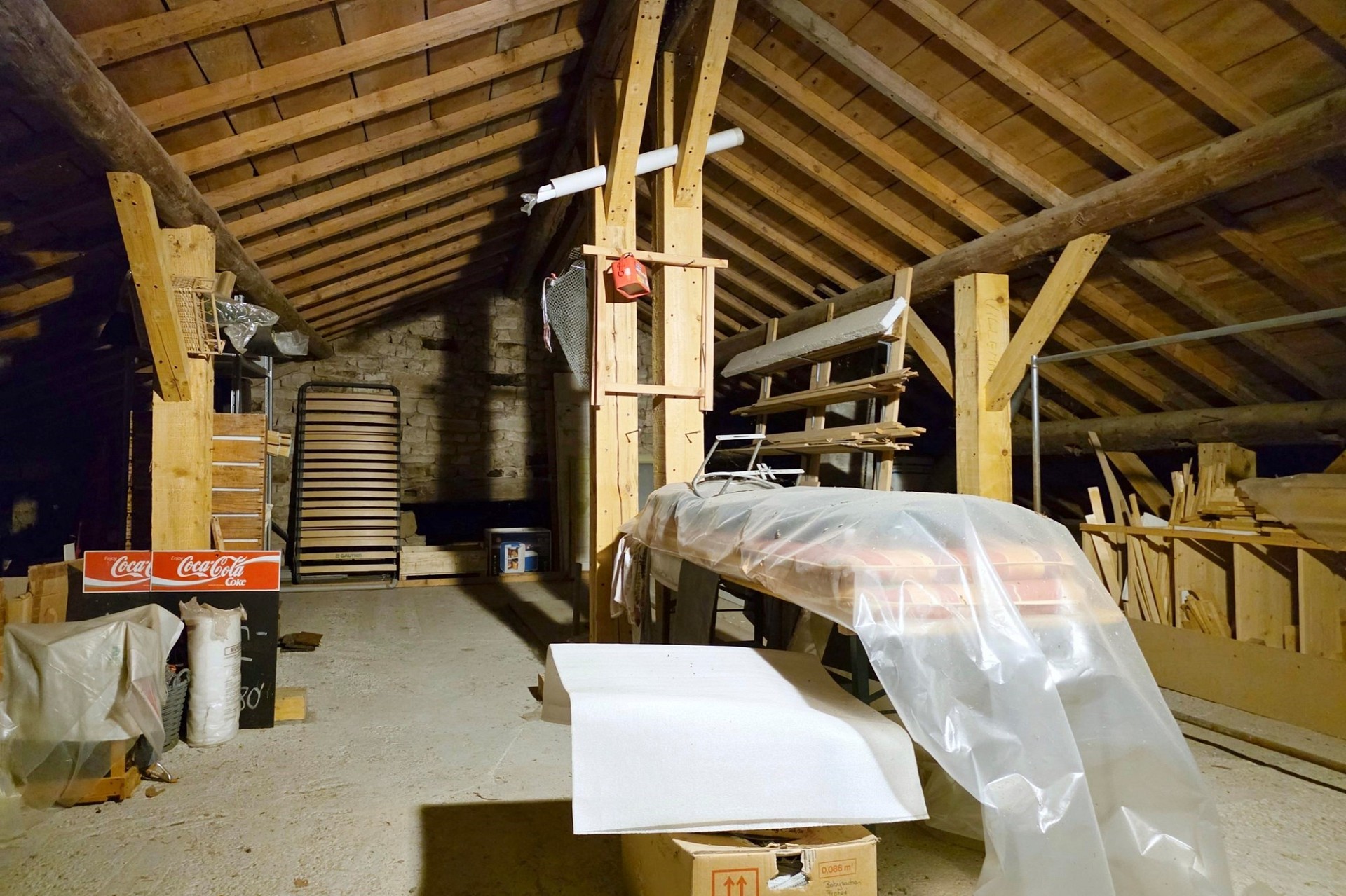 Dachboden mit sichtbarem Fachwerk und gelagerten Materialien
