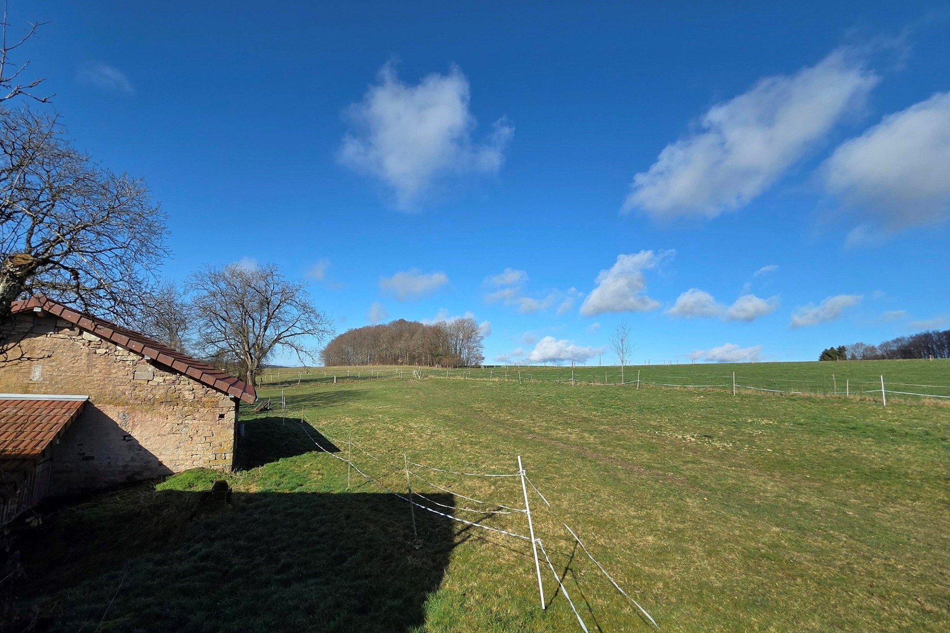 Ländliche Außenansicht mit Wiese und altem Gebäude