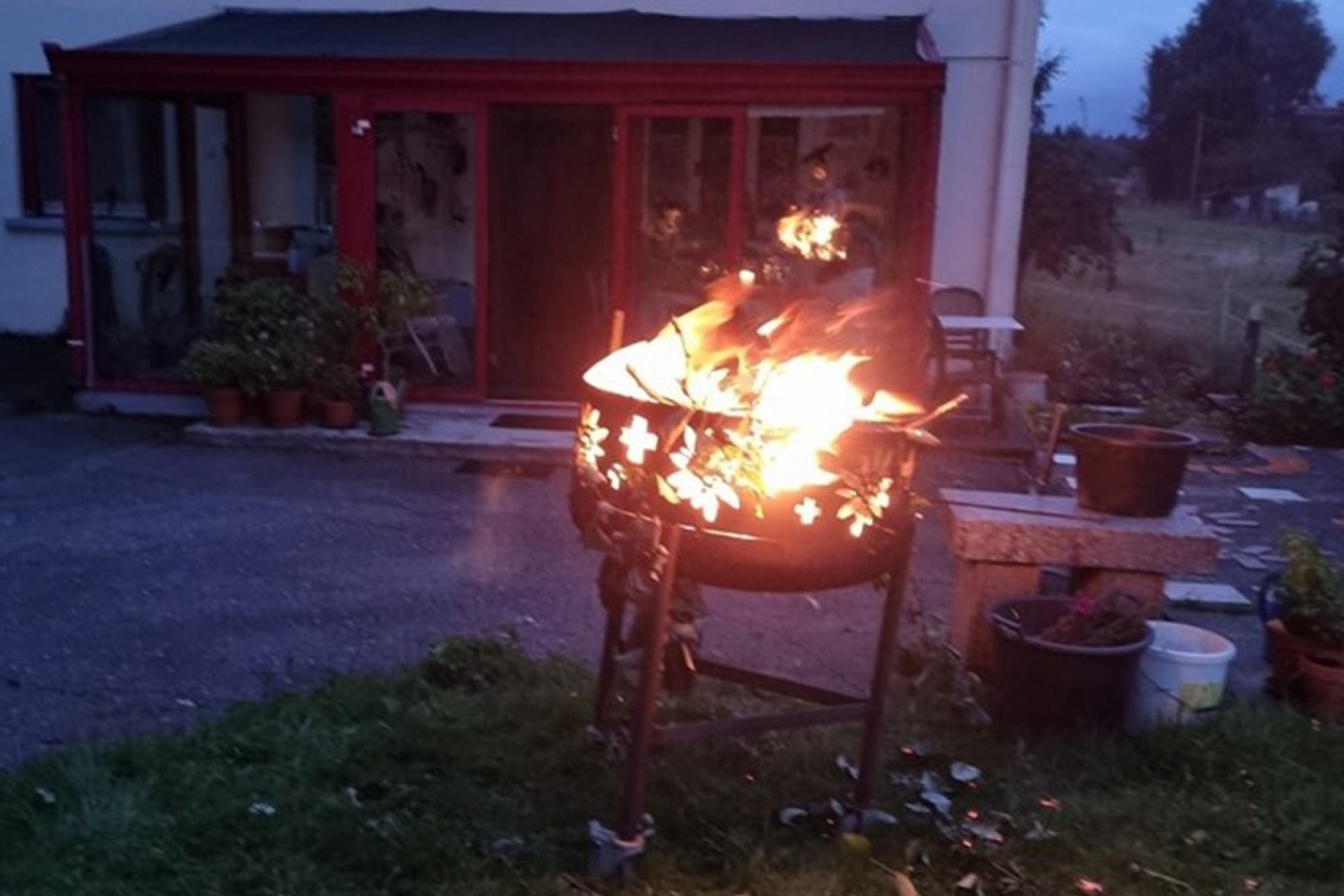 Außenaufnahme mit brennender Feuerschale im Garten