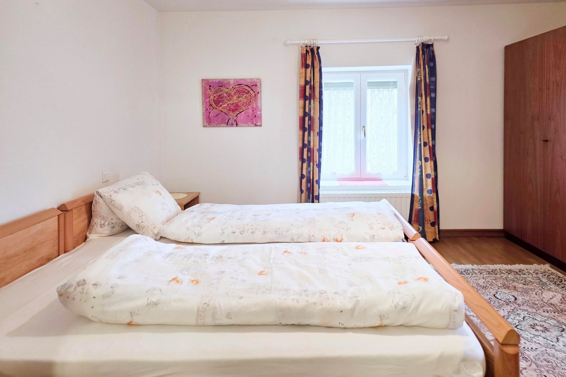 Helles Schlafzimmer mit Doppelbett und Fenster