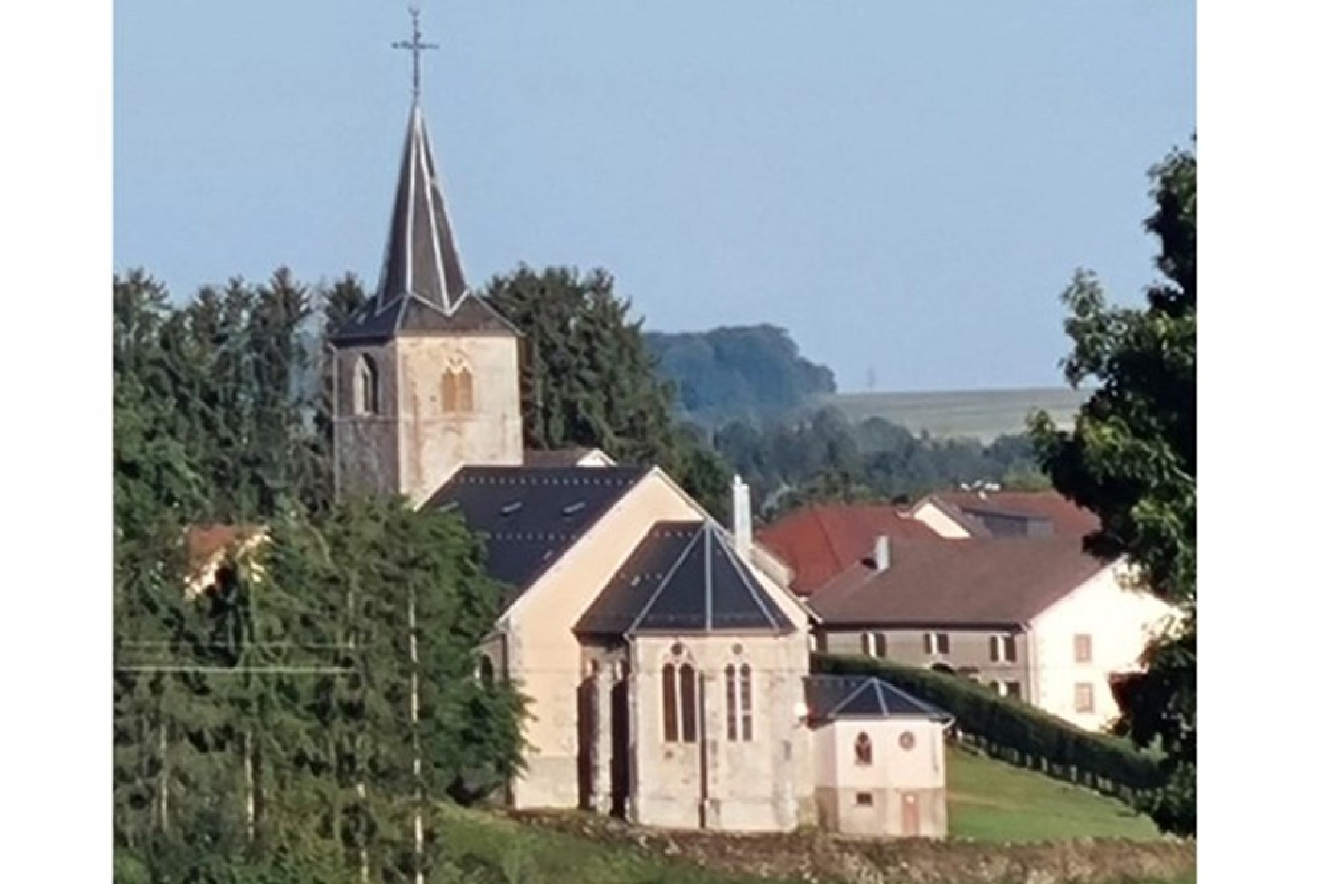 Kirche mit hohem Turm in ländlicher Umgebung