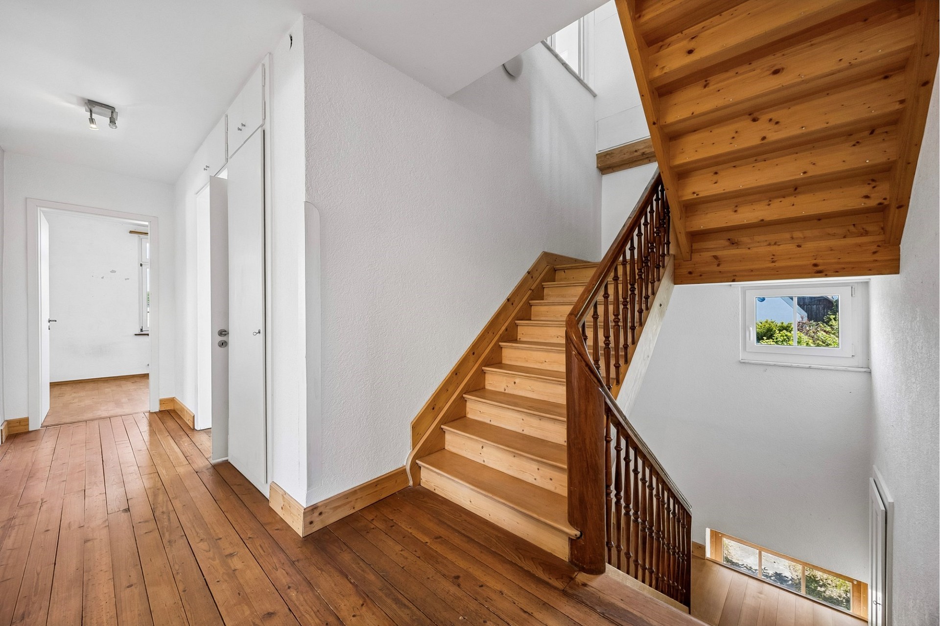 Heller Treppenflur mit Holztreppe
