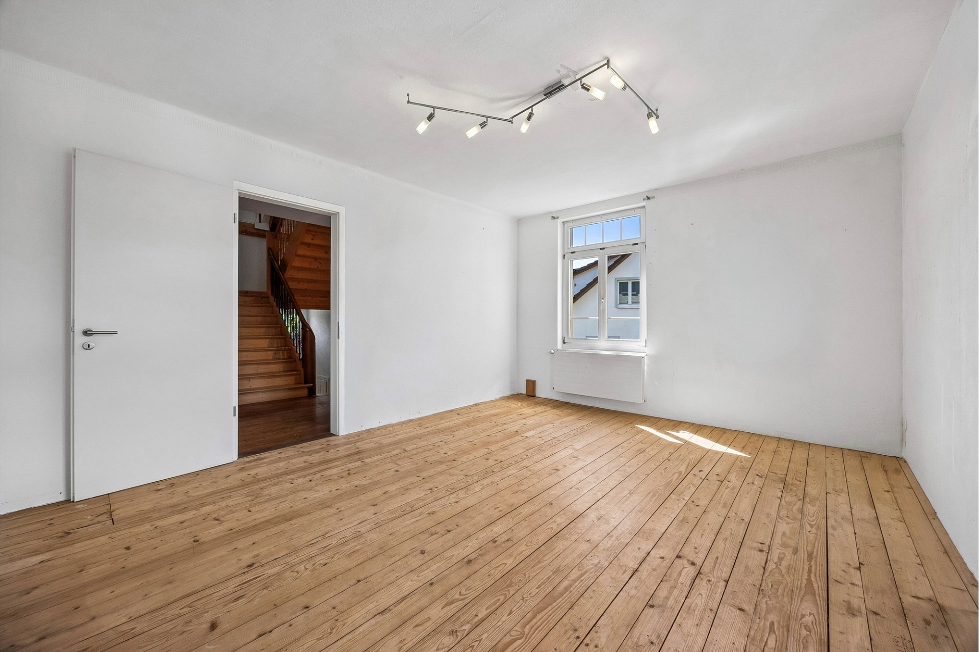 Heller leerer Raum mit Holzdielen und Fenster