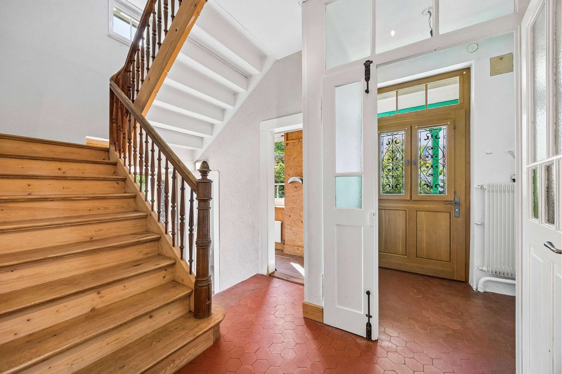 Heller Eingangsbereich mit Holztreppe