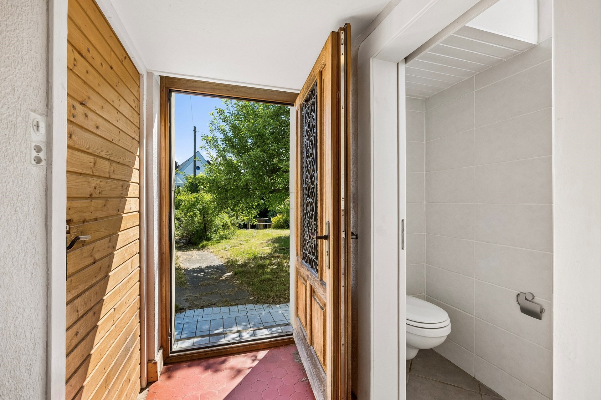 Eingangsbereich mit offener Haustür und separatem WC