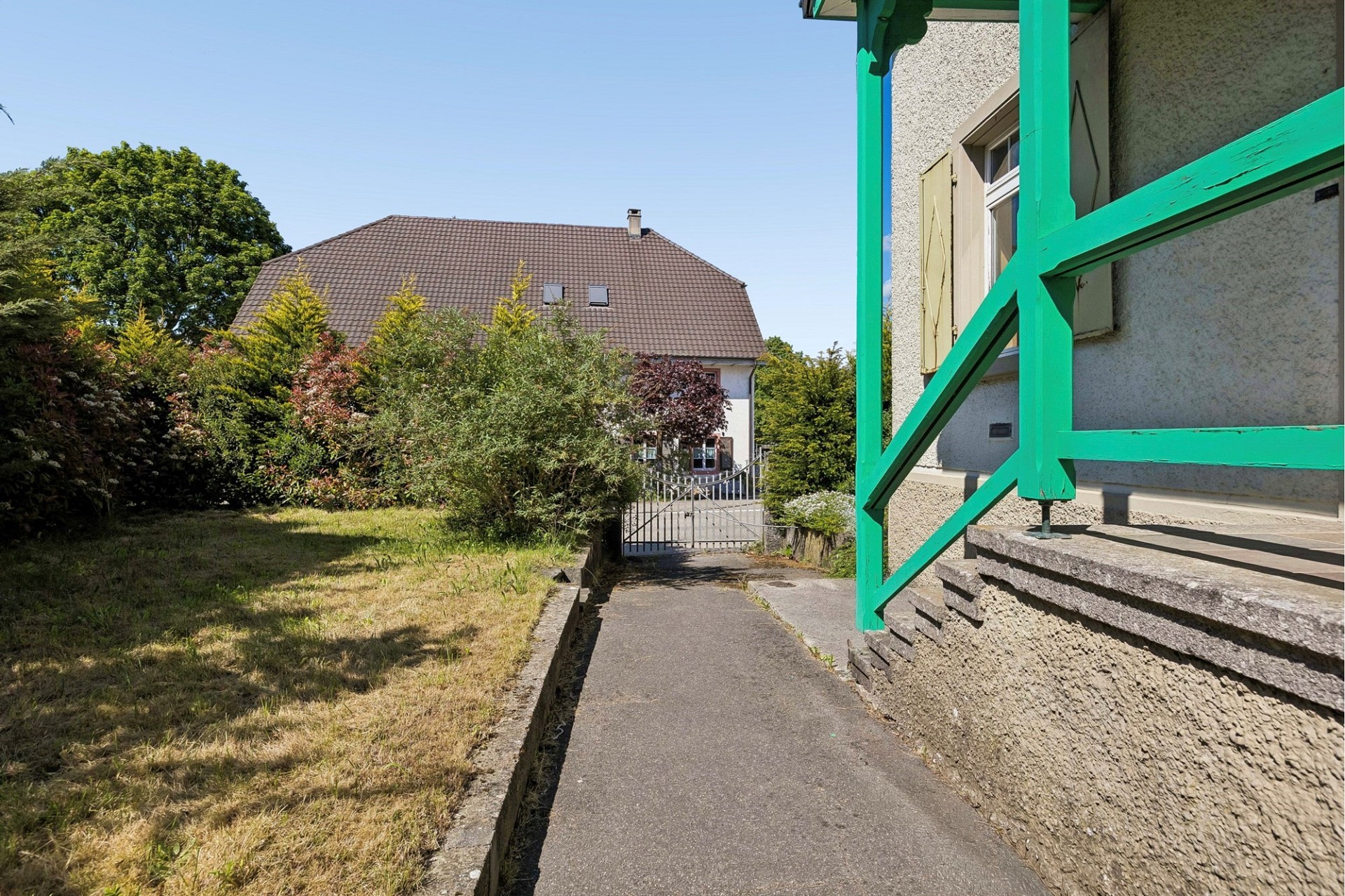 Außenansicht eines Einfamilienhauses mit Garten und Zufahrt