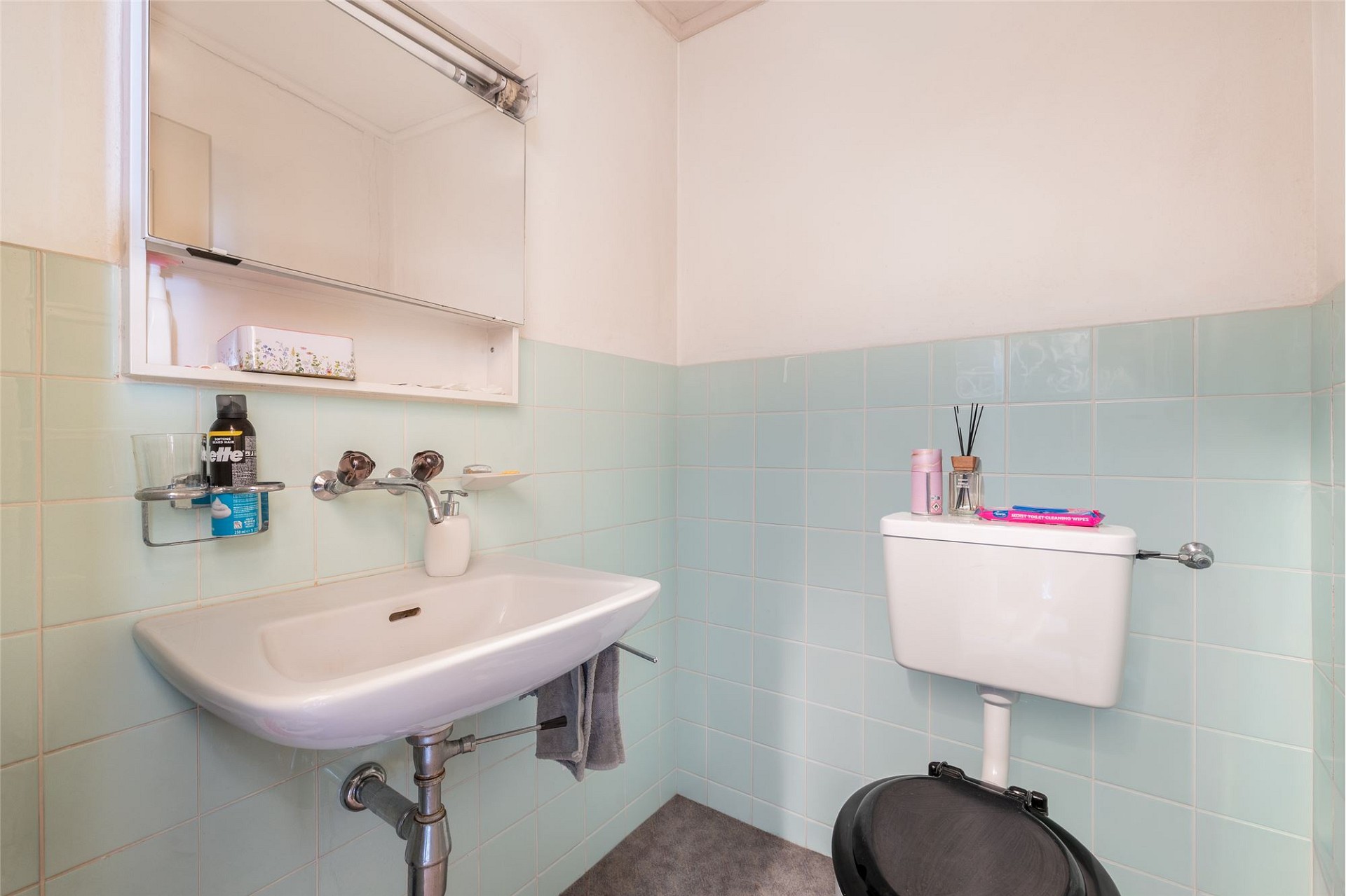 Kleines Gäste-WC mit Wandfliesen und Handwaschbecken