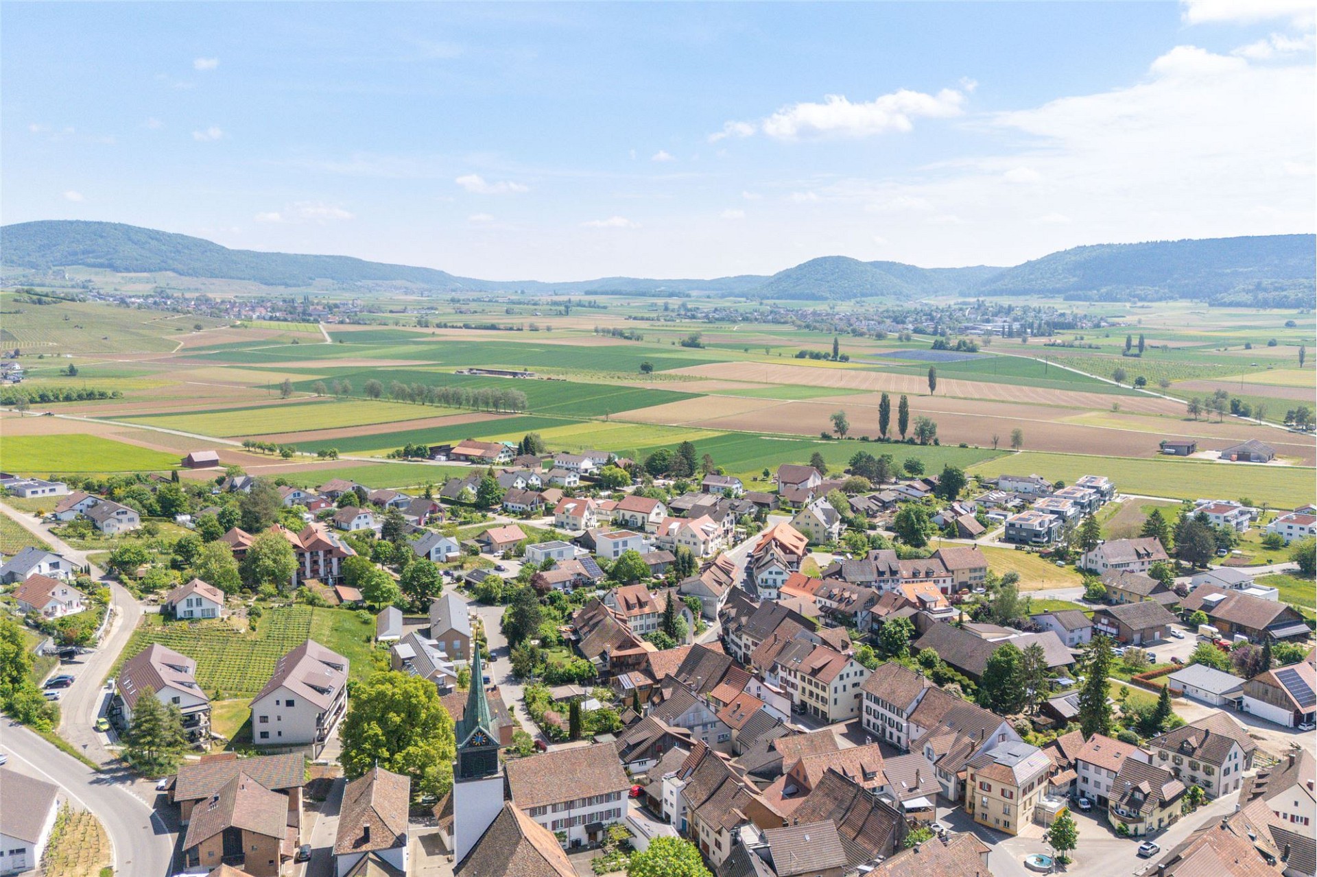 Luftaufnahme eines Dorfes in ländlicher Tallandschaft