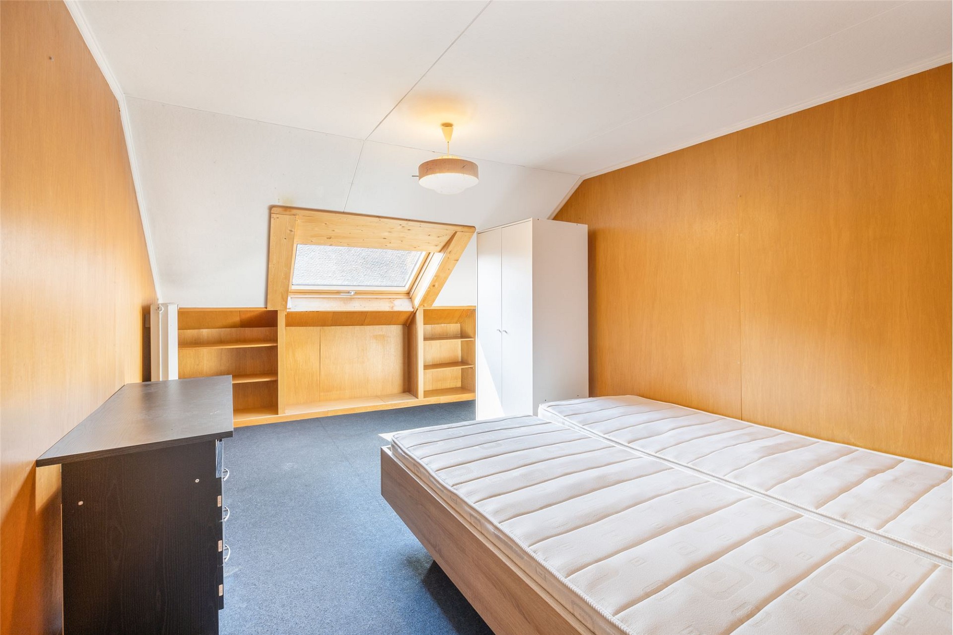 Dachzimmer mit Bett und Stauraum
