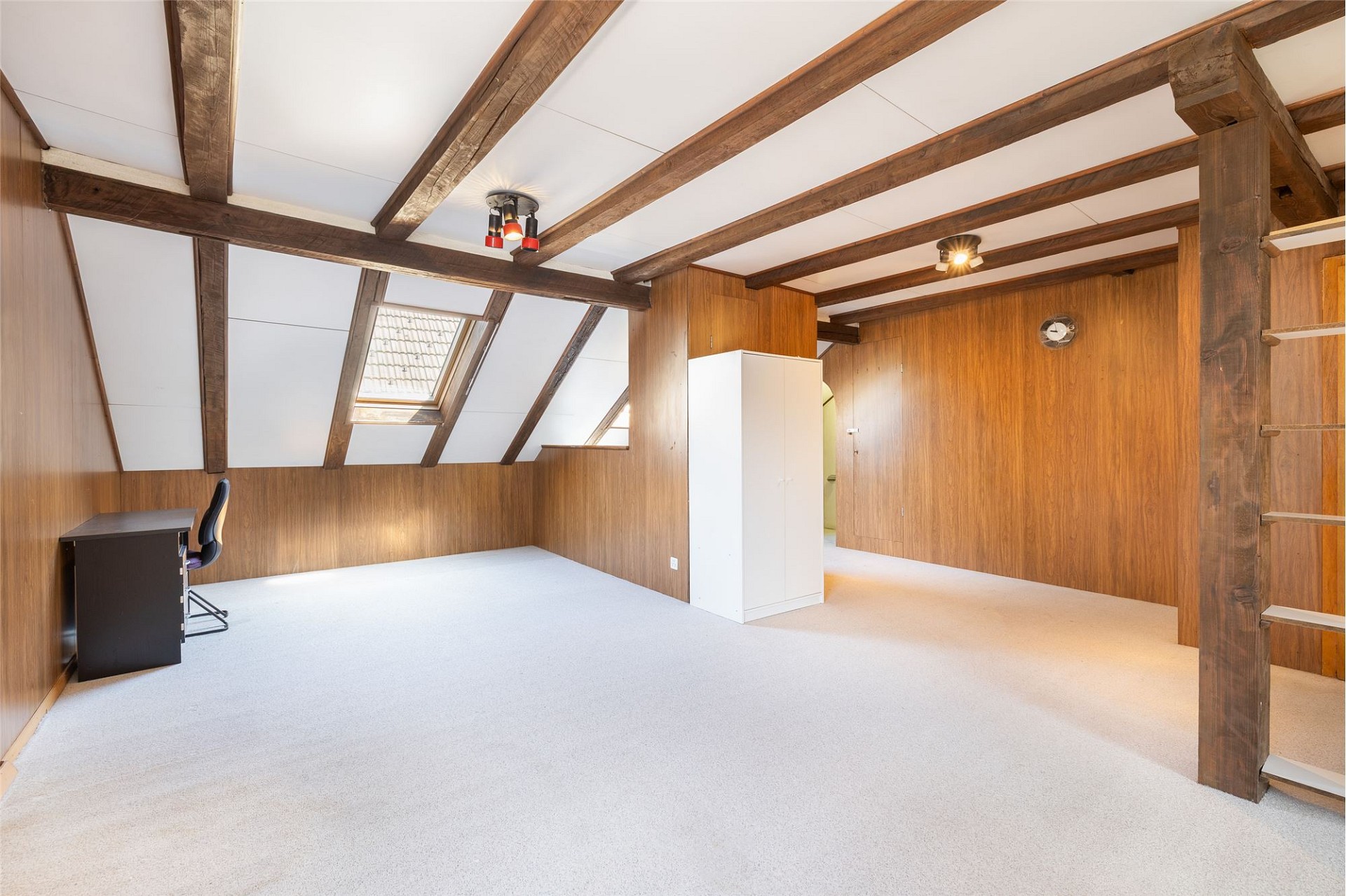 Dachgeschossraum mit sichtbaren Holzbalken