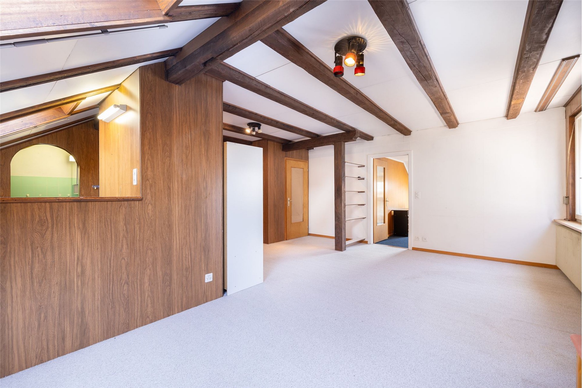 Ausgebauter Dachgeschossraum mit sichtbaren Holzbalken