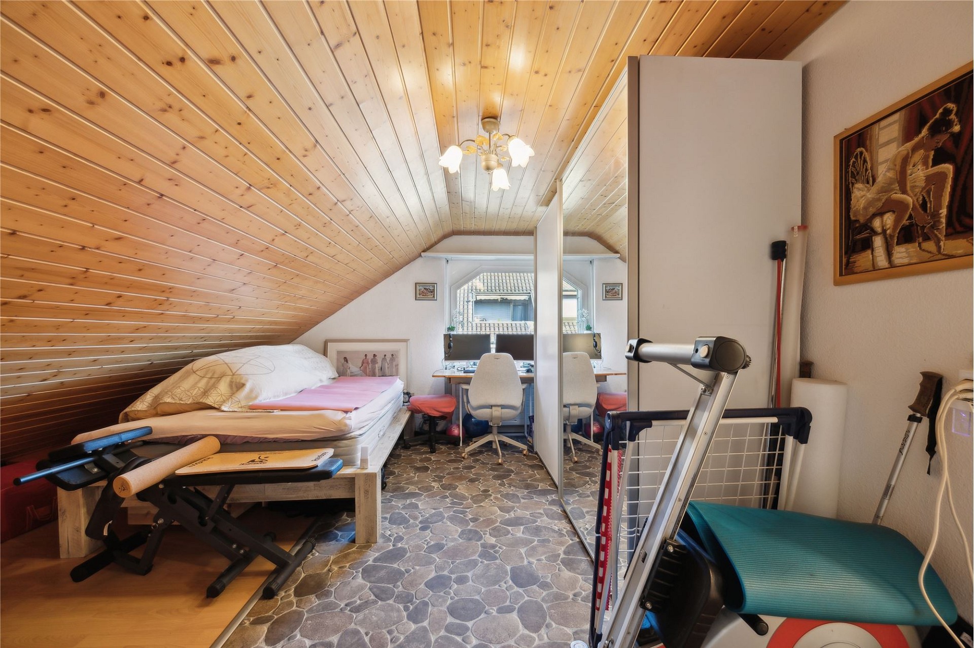 Dachgeschosszimmer mit Bett und Arbeitsplatz
