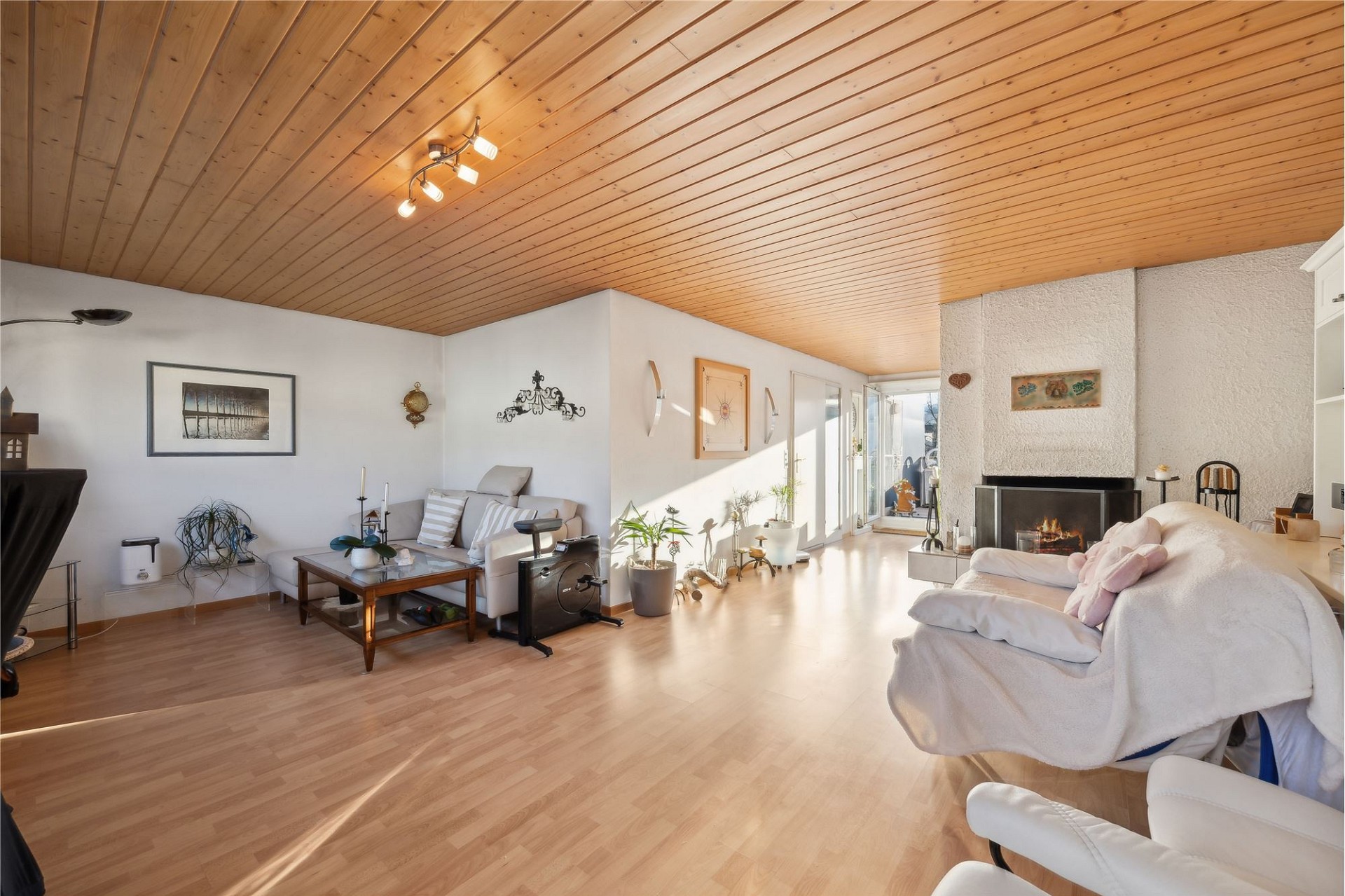 Heller Wohnraum mit Holzbalkendecke und Kamin