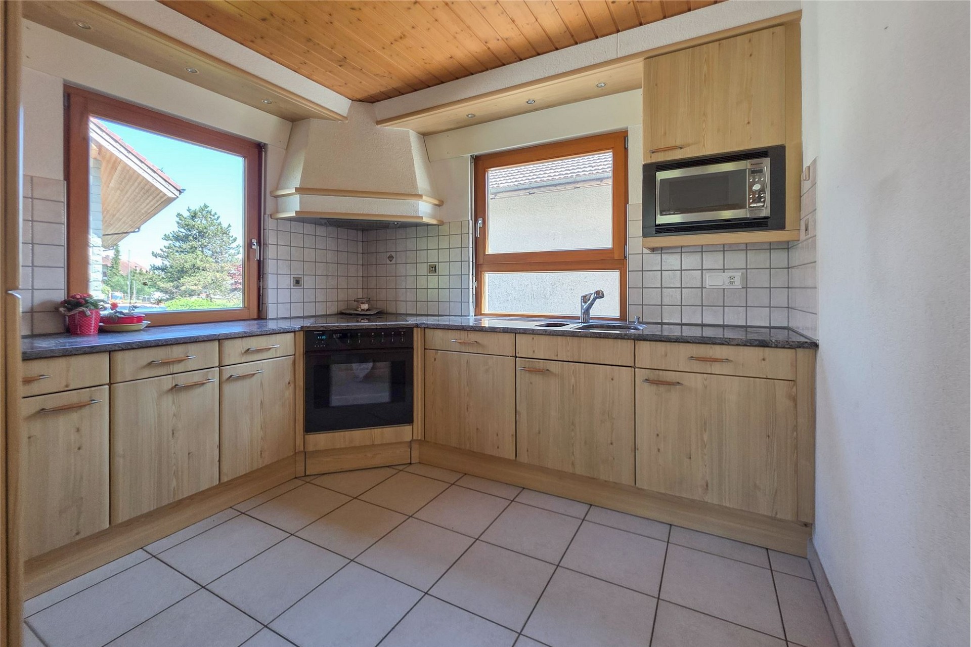 Helle Einbauküche mit Holzoptik und Dachfenstern