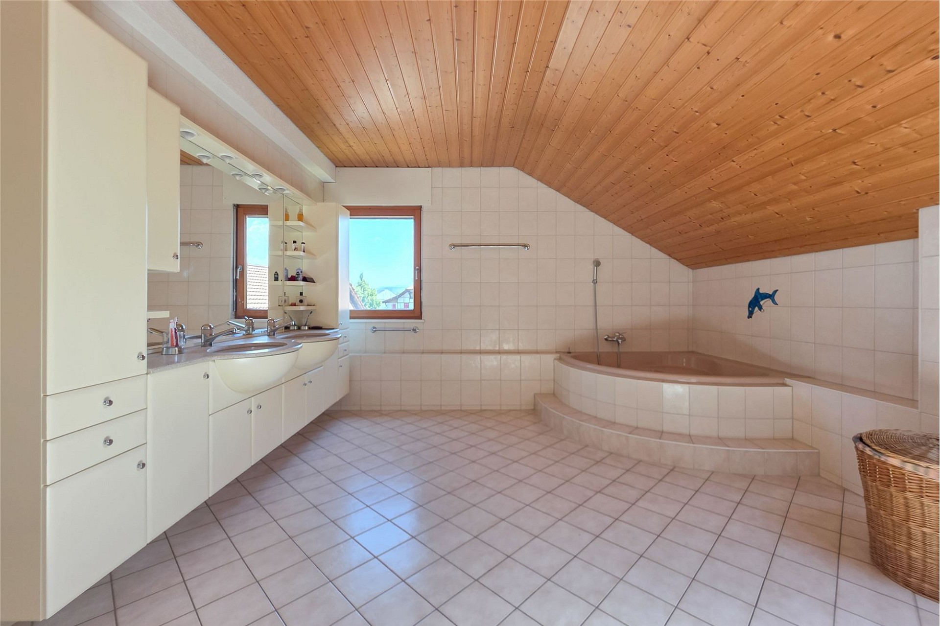 Badezimmer mit Holzdecke und Eckwanne