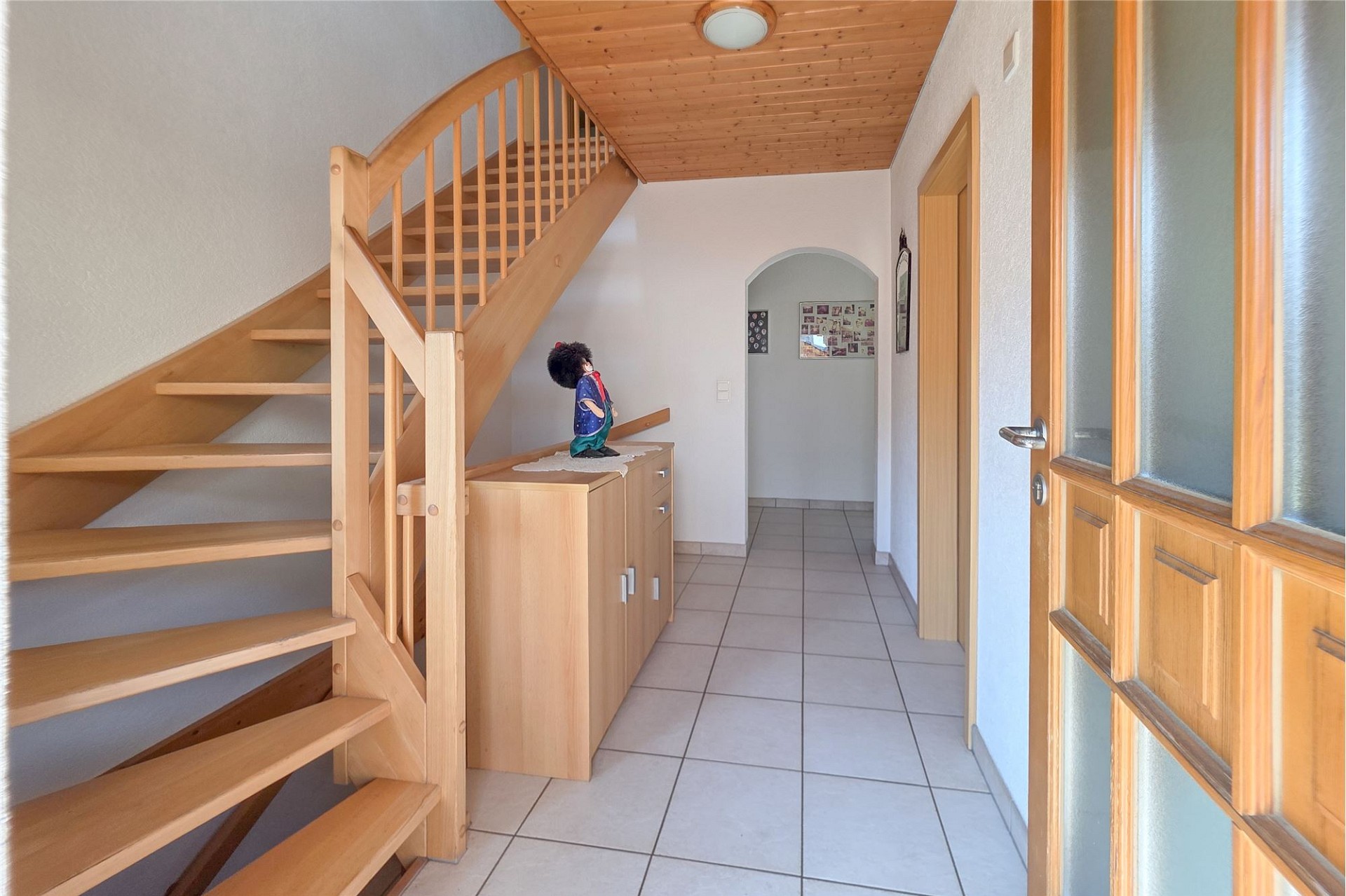 Heller Flur mit Holztreppe