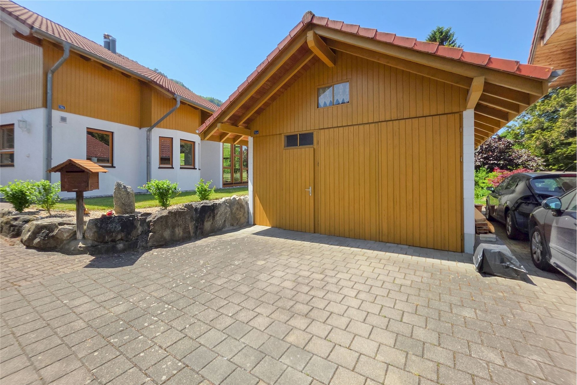 Außenansicht eines Holzhauses mit Garage