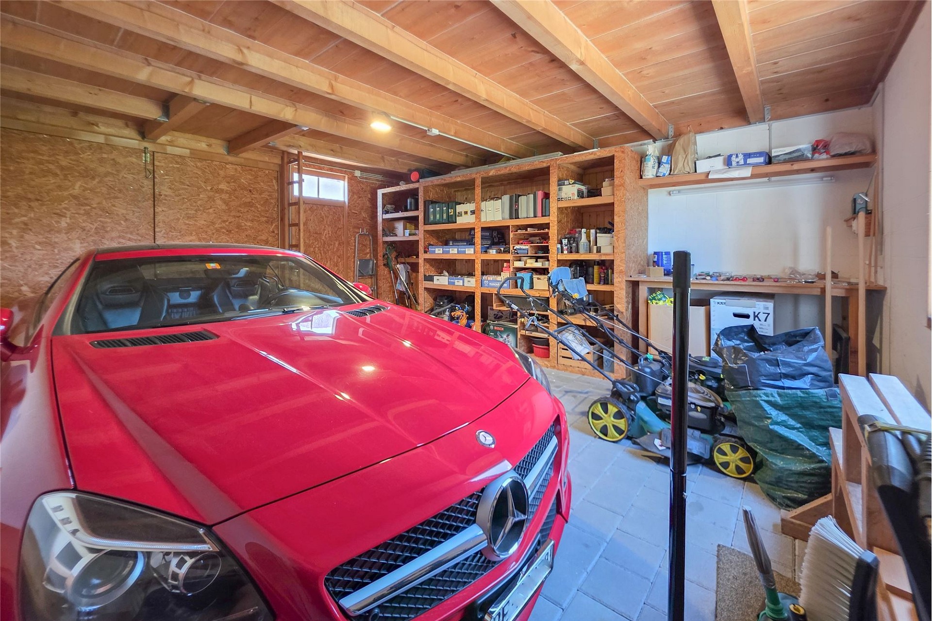Garage mit Sportwagen und Werkstattregalen
