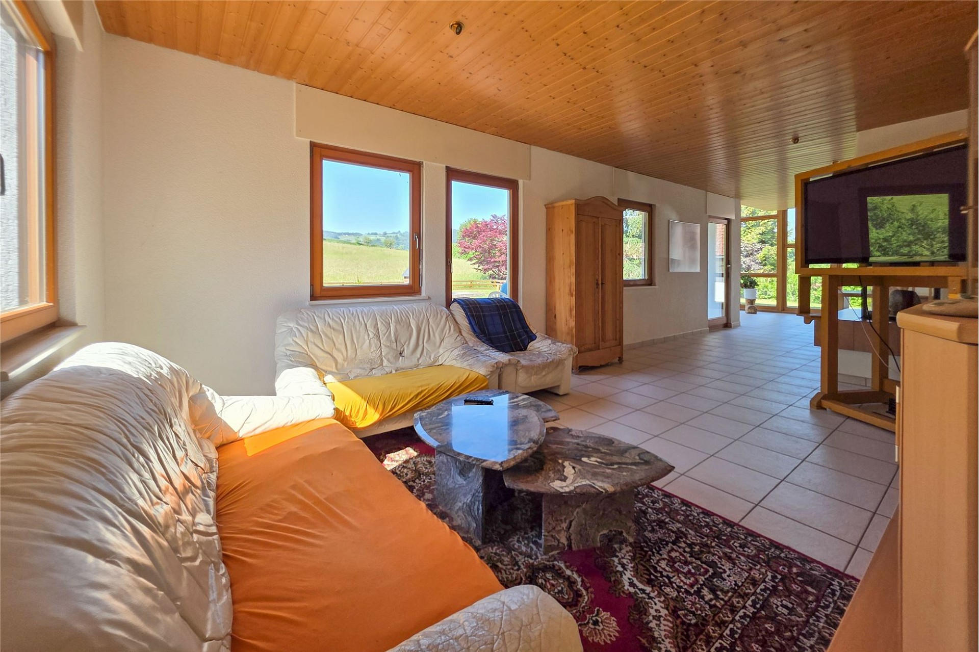 Helles Wohnzimmer mit Panoramafenstern und Naturblick